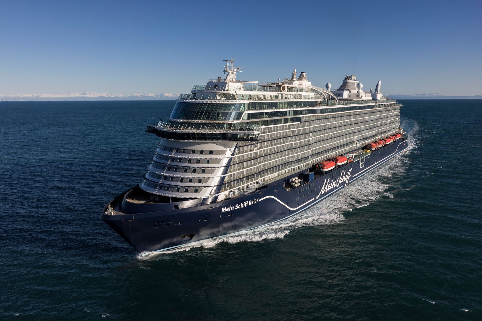 Newsroom - Comunicati stampa - 2025 - Gruppo Fincantieri:  Fondazione Fincantieri: consegnati a Sestri Ponente gli attestati dei corsi di italiano per lavoratori stranieri: Nave da crociera Fincantieri in navigazione su mare calmo, vista aerea laterale con cielo sereno.
