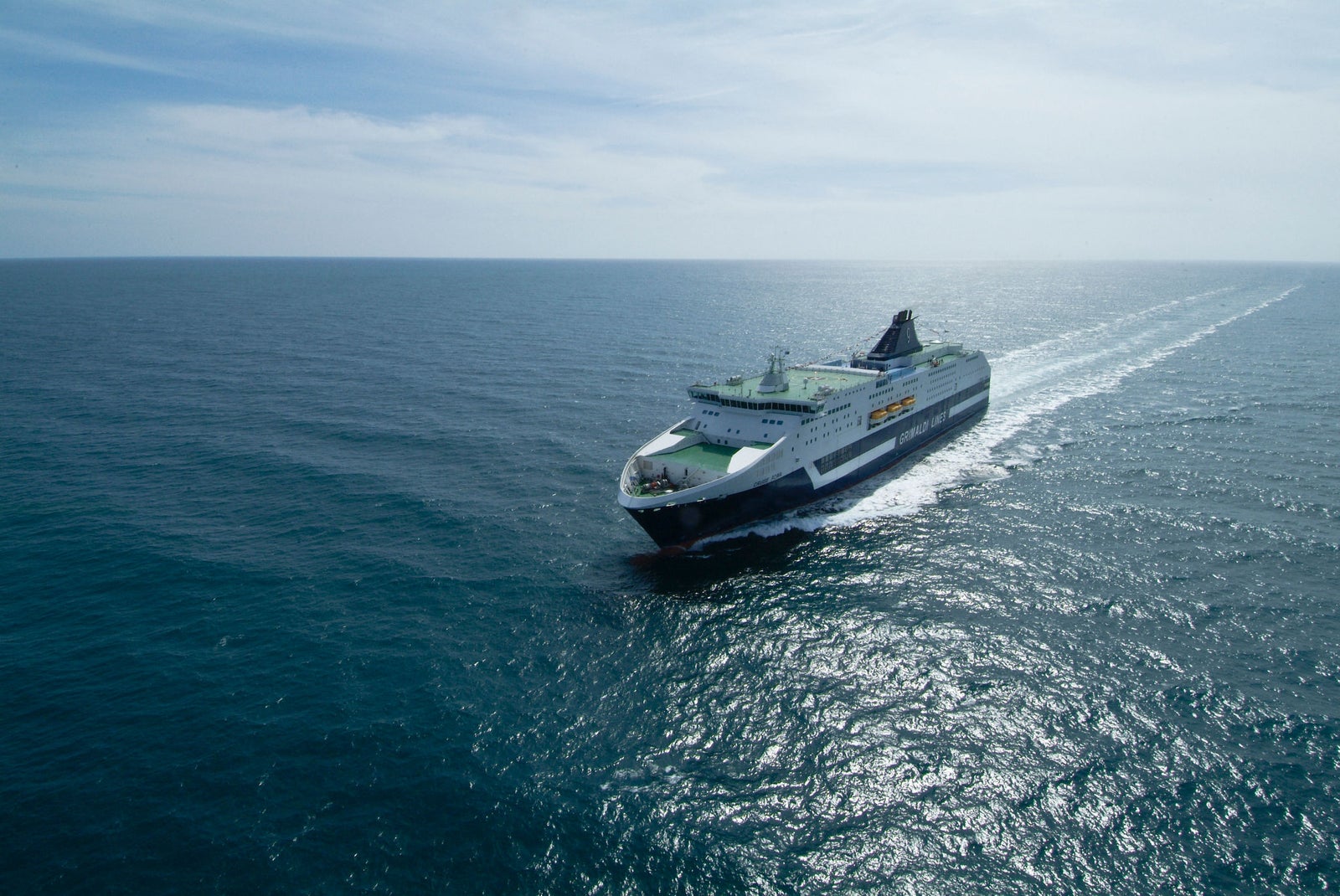 Prodotto - Nave da crociera Eurodam: Due grandi fumaioli bianchi con cima nera sono ben visibili su una nave da crociera. I fumaioli mostrano chiaramente un logo con una nave a vela all’interno di un design circolare. Lo sfondo è un oceano aperto con acque calme e blu che si estendono all’orizzonte.