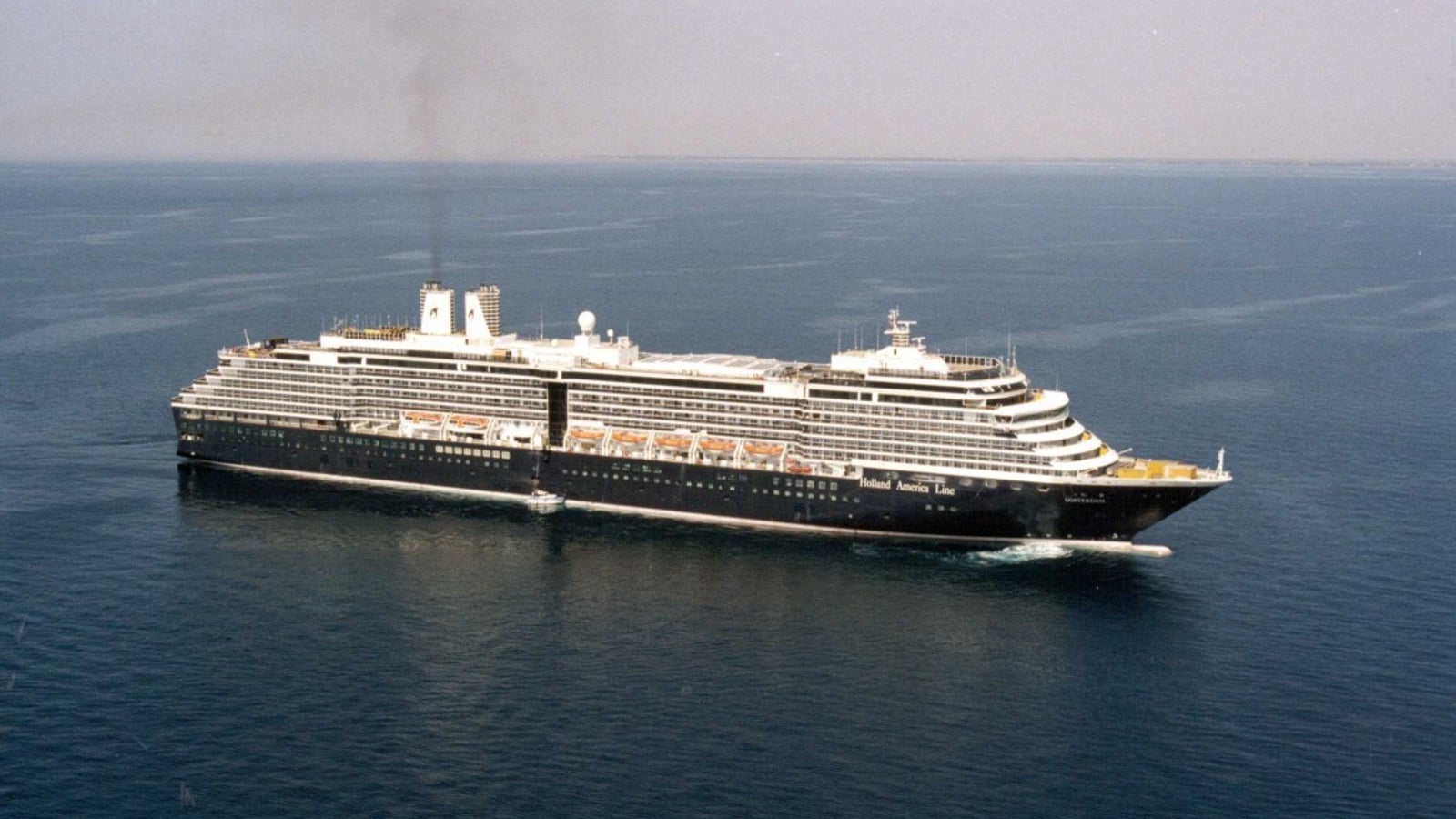 Fincantieri | Group - Business - Products - Cruise Ships - Oosterdam: View of Oosterdam cruise ship in operation, multiple passenger decks, lifeboats, and active funnel.