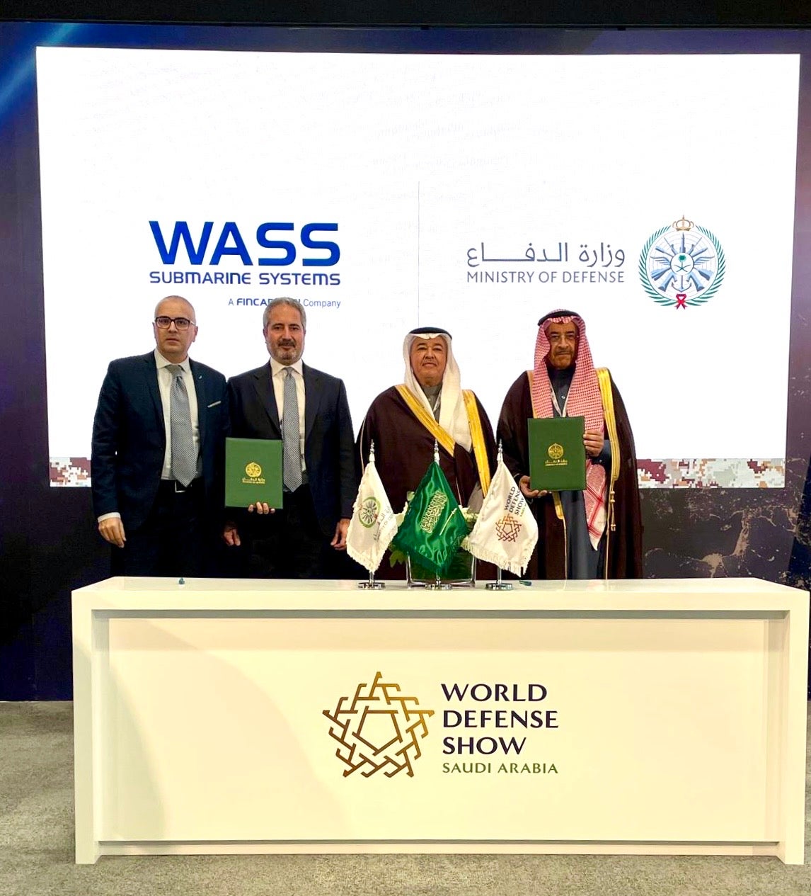 Newsroom - Press releases - 2026 - Fincantieri Group: fincantieri group: wass secures contract to supply torpedoes to the royal saudi naval force: executives from wass and saudi ministry of defense in formal attire hold agreement at signing ceremony with flags.