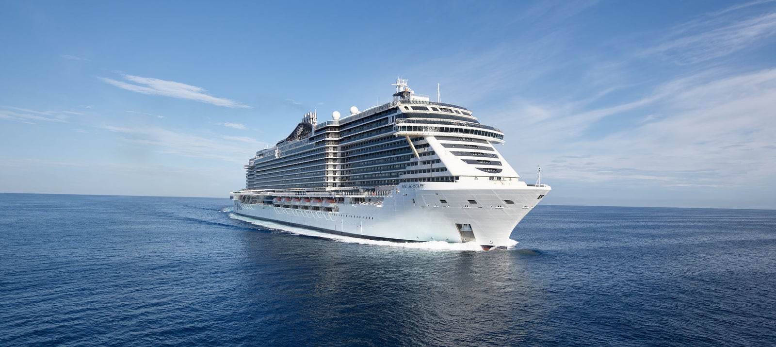 Fincantieri | Products - Services - Ship Repair and Conversion - Cruise Ship: Modern operational ship with multiple decks and elegant design sailing, blue waters and clear sky, intended for travel and leisure.