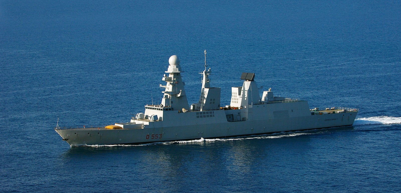  Fincantieri | Gruppo - Business - Prodotti - Navi per la difesa - Cacciatorpediniere - Classe Andrea Doria: Vista laterale della nave operativa in navigazione, scafo grigio, sistemi radar avanzati, numero D551 ben visibile sullo scafo.