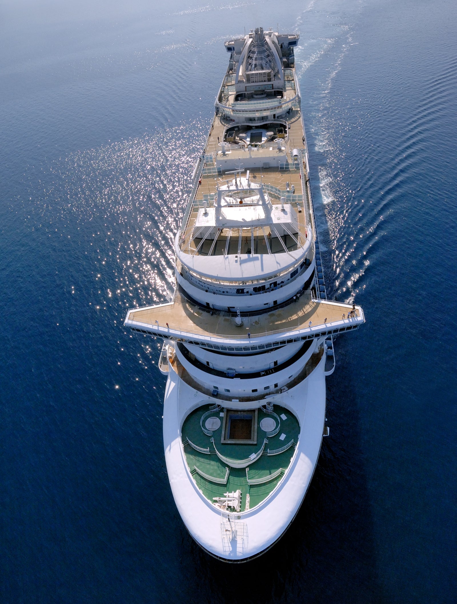 Fincantieri | Gruppo - Business - Prodotti - Navi da Crociera - Ruby Princess: Vista aerea di grande nave da crociera di lusso operativa che naviga su acque profonde e calme di blu intenso, molti ponti, area piscina e spazi ricreativi.