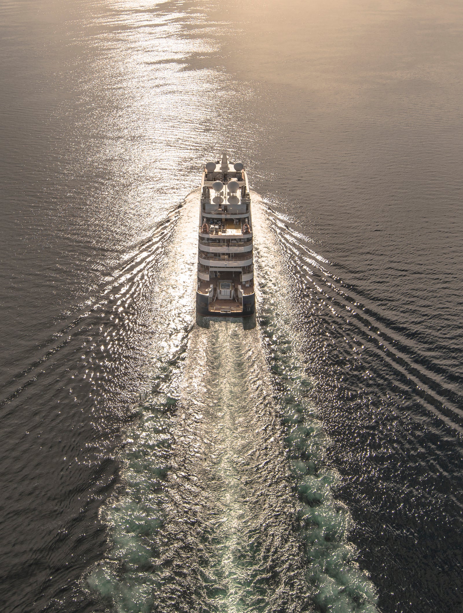  Fincantieri | Gruppo - Business - Prodotti - Navi da Crociera - Le Lapérouse: Vista aerea della nave Le Lapérouse operativa in navigazione su mare aperto, scafo dal profilo lineare, ponti passeggeri multipli, scia visibile in acqua.