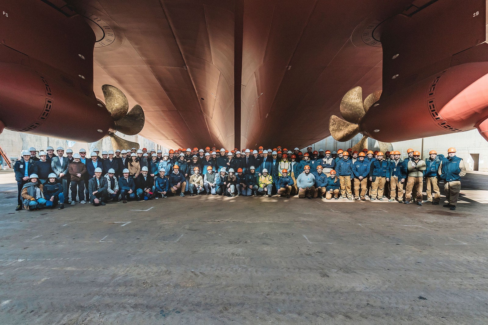 Newsroom - Press releases - 2026 - Fincantieri Group: Fincantieri: “Viking Libra” launched in Ancona, the world’s first hydrogen-powered cruise ship: Large group of workers and engineers with helmets posing under the hull and propellers of the cruise ship Viking Libra.