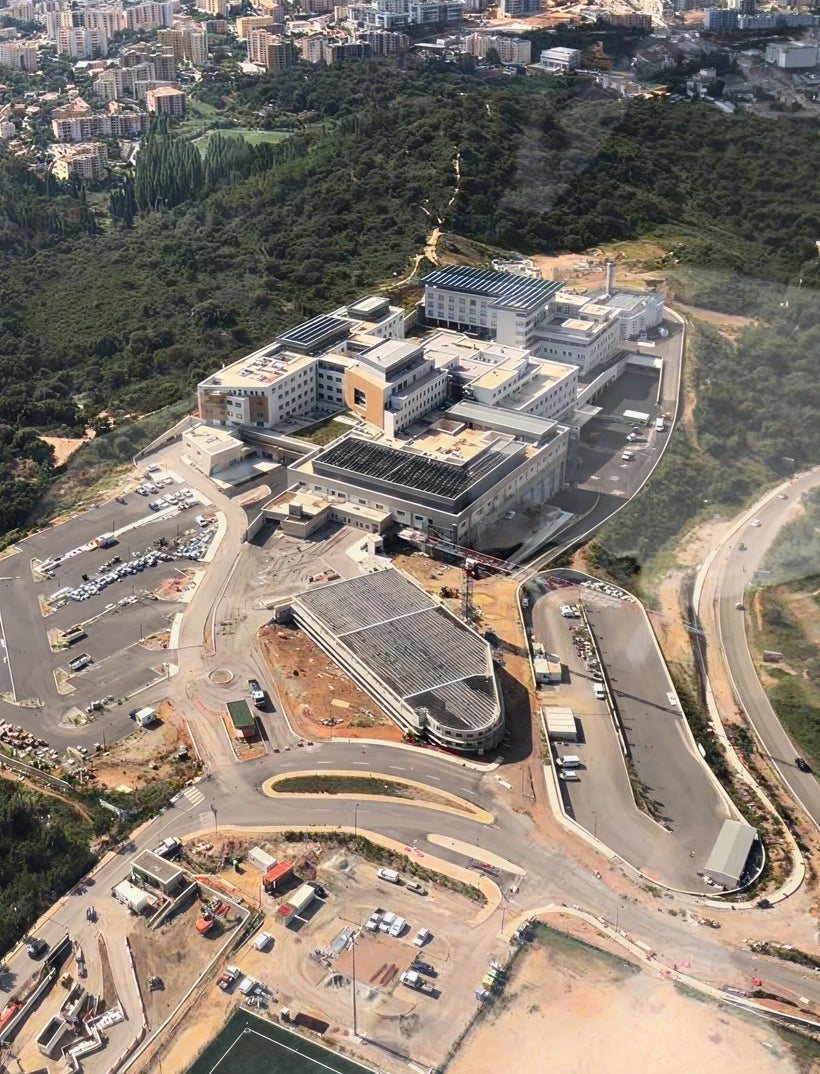 Fincantieri | Gruppo - Società - Controllate e collegate - Finso: Complesso ospedaliero moderno ripreso dall’alto, architettura contemporanea e infrastrutture circostanti; presenza di strade, parcheggi e aree verdi, enfasi su scala e design della struttura in contesto urbano.