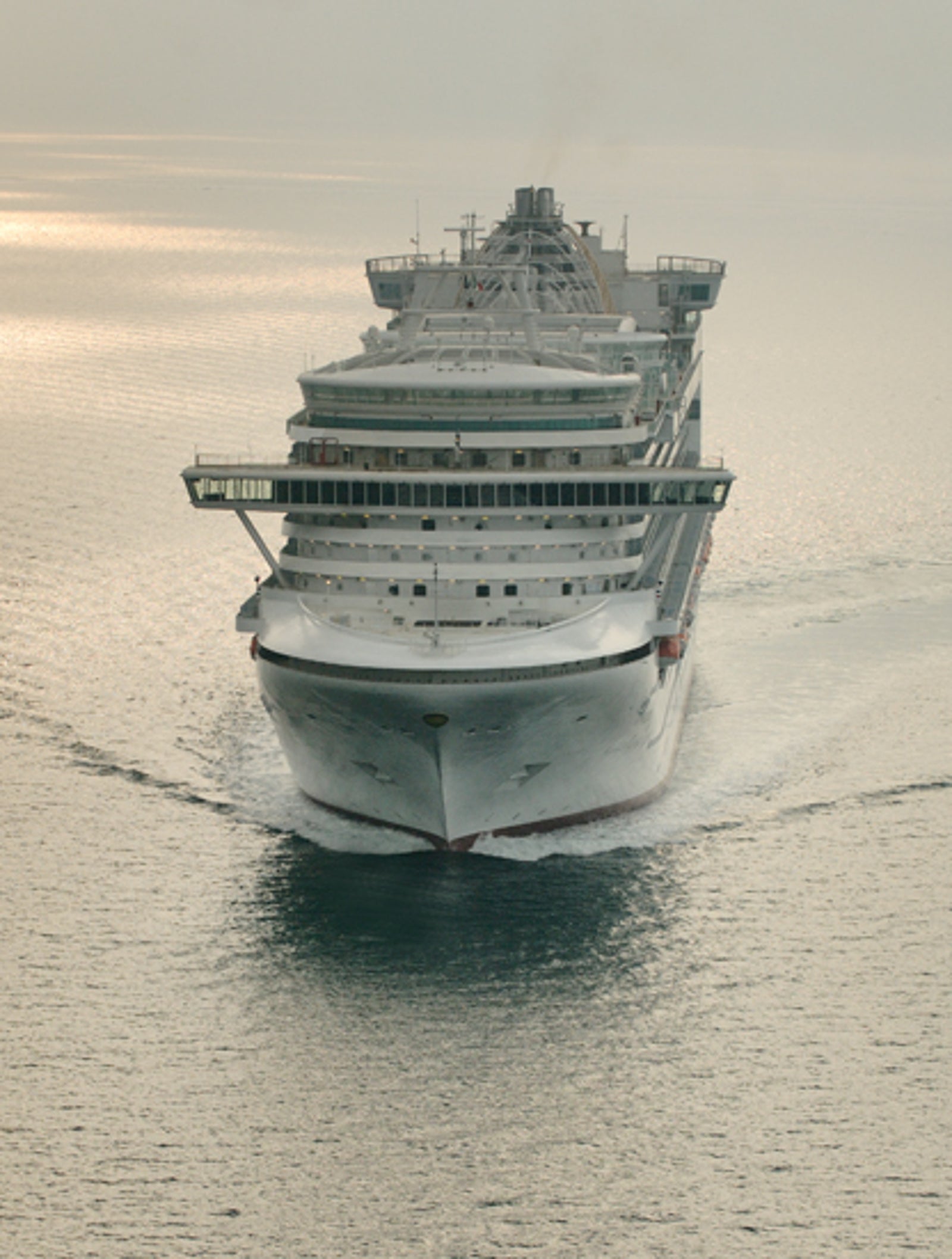 Fincantieri | Group - Business - Products - Cruise Ships - Ventura: Side view of Ventura cruise ship in operation navigating at sunrise, white hull with multiple passenger decks and prominent structure.