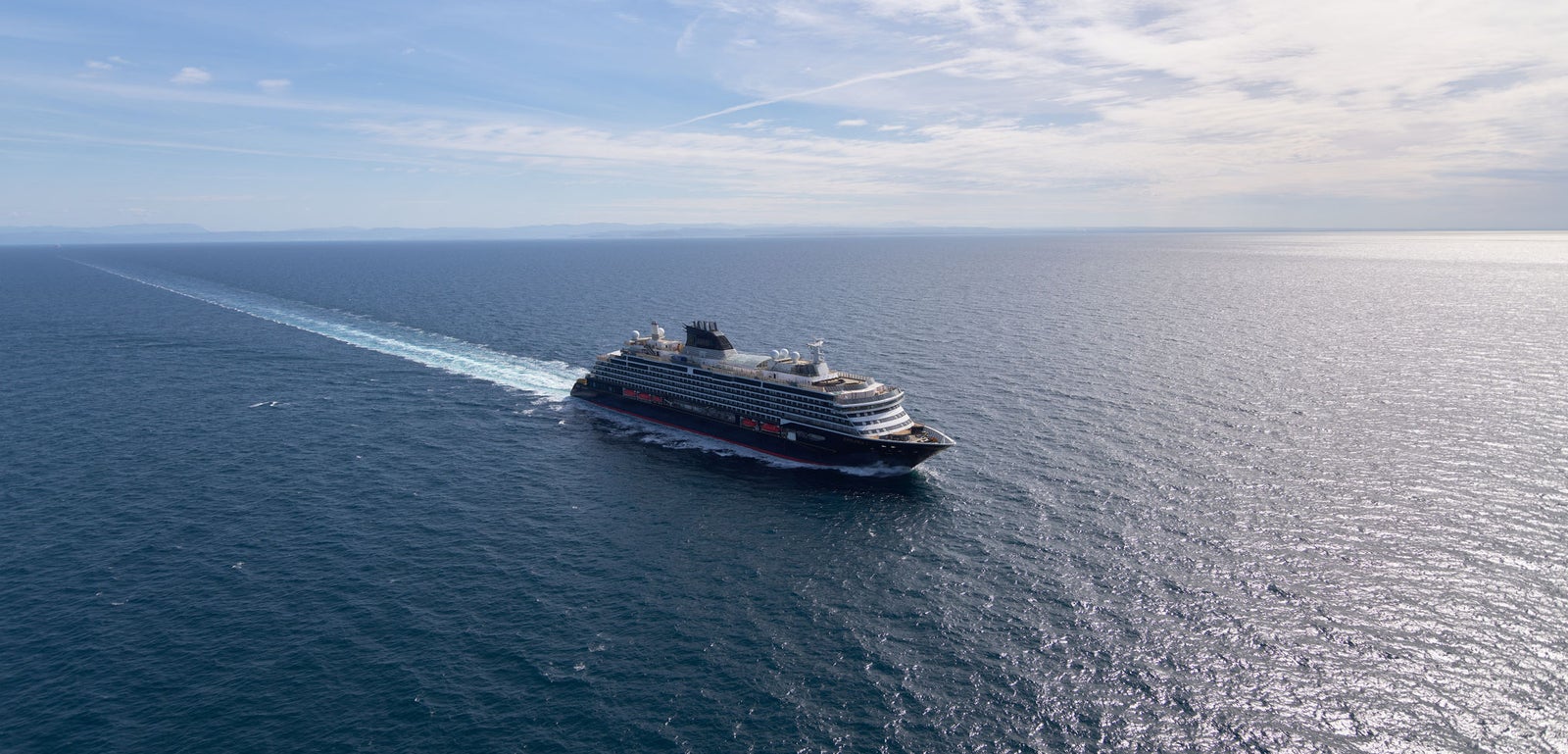 Fincantieri | Group - Business - Products - Cruise Ships - Explora I: Luxury cruise ship in operation, navigating open sea, visible wake.