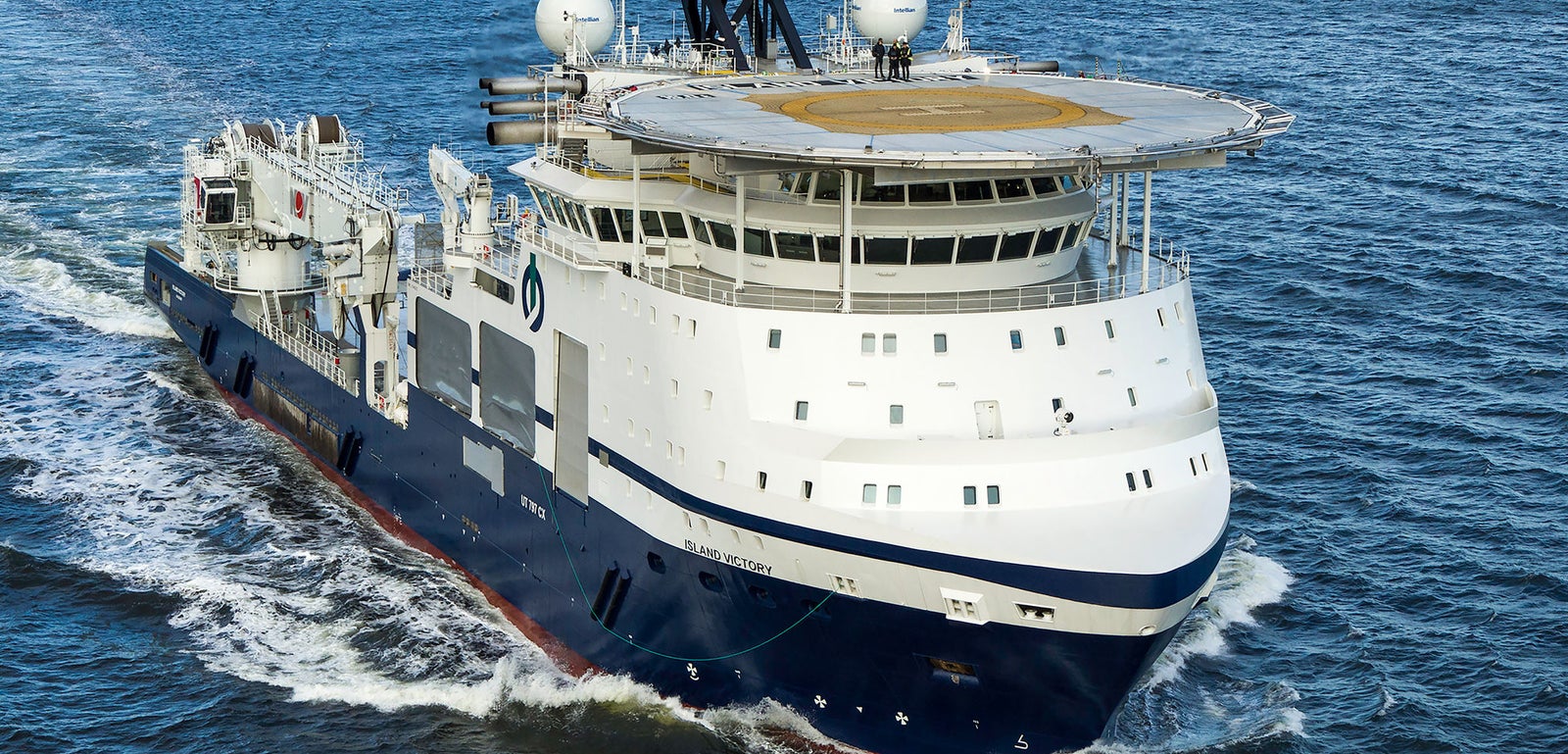 Prodotto - Offshore Vessel Island Victory: Vista laterale della nave operativa in navigazione, elisuperficie prominente sul ponte, attrezzature avanzate per operazioni offshore, scafo bianco e blu navy, dettagli strutturali visibili.