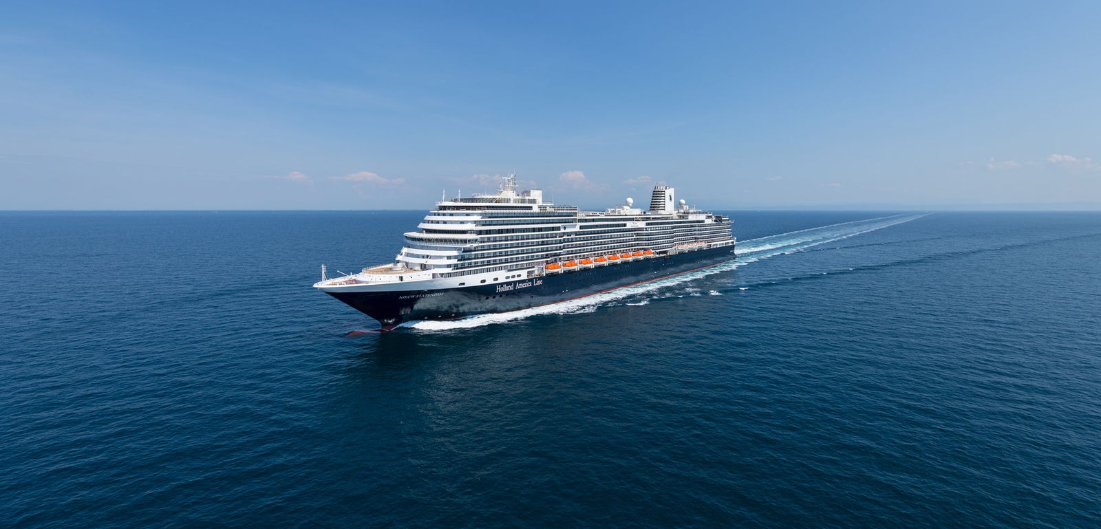 Fincantieri | Gruppo - Business - Prodotti - Navi da Crociera - Nieuw Statendam: Grande nave da crociera moderna operativa che scivola su mare calmo e aperto sotto cielo azzurro limpido, più ponti e design elegante, atmosfera di maestosità e avventura.
