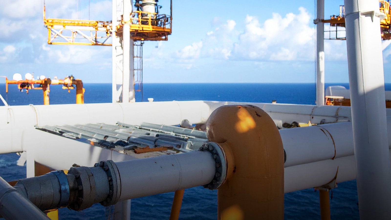 Newsroom - Press releases - 2026 - Fincantieri Group: Fincantieri Group: Remazel completes the acquisition of H Tech Serviços e Manutenção Ltda: Industrial offshore platform structures with pipes and yellow crane systems, sea and sky in the background.
