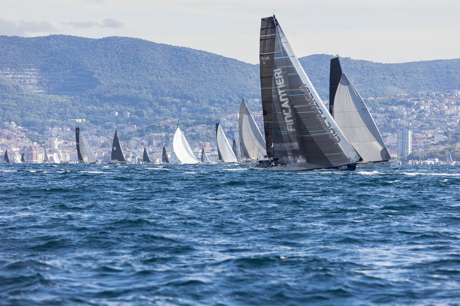Fleet of sailboats racing on open sea