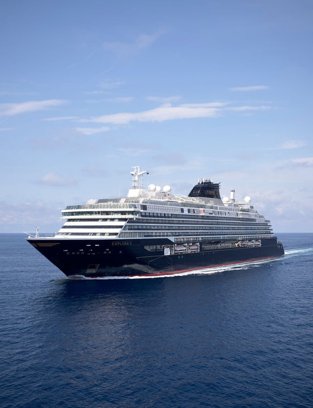 Fincantieri | Gruppo - Innovazione - Ecosistema navale del futuro - Energy Efficency: Nave da crociera moderna operativa con più ponti e design elegante in navigazione su acque blu calme sotto cielo sereno, progettata per viaggi e tempo libero.