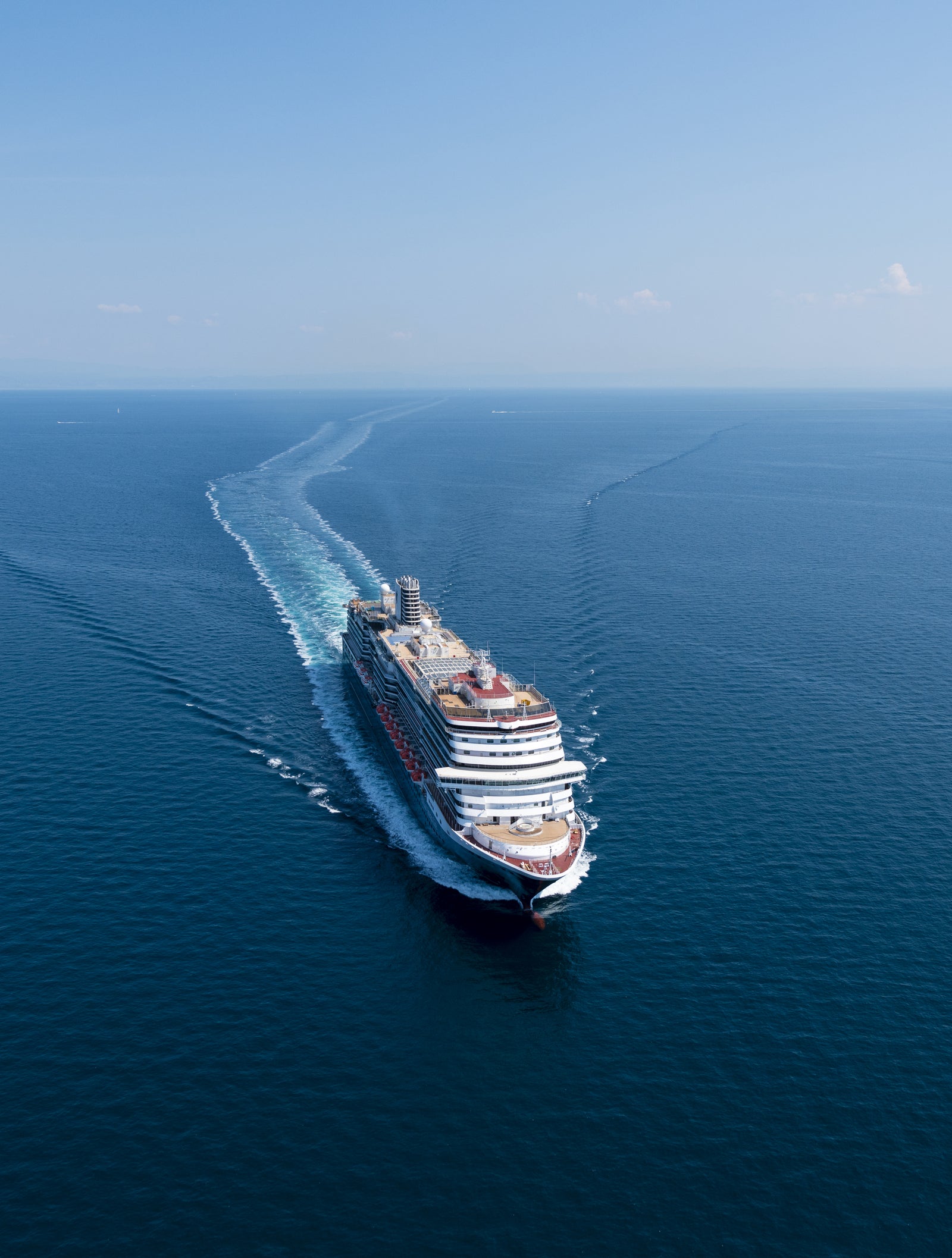  Fincantieri | Gruppo - Business - Prodotti - Navi da Crociera - Nieuw Statendam: Grande nave da crociera operativa che naviga su acque calme e aperte sotto cielo azzurro limpido, scia visibile dietro la nave che ne evidenzia maestosità e scala.