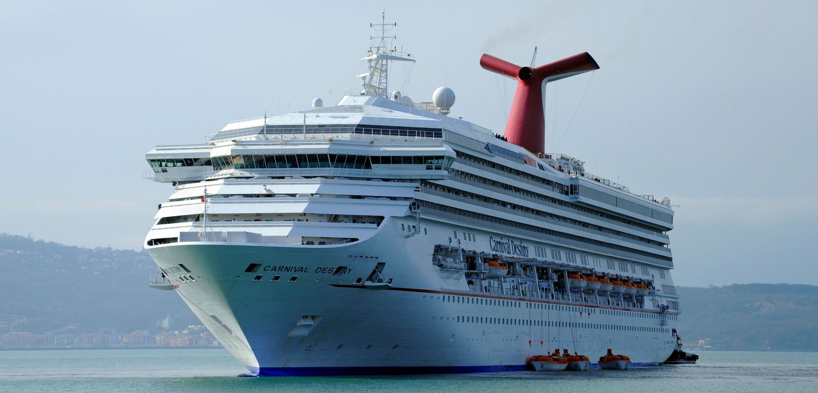 Fincantieri | Group - Business - Products - Cruise Ships - Carnival Destiny: Large white cruise ship identified as 'Carnival Pride' in operation sailing on calm waters, multiple decks, lifeboats, distinctive red funnel.