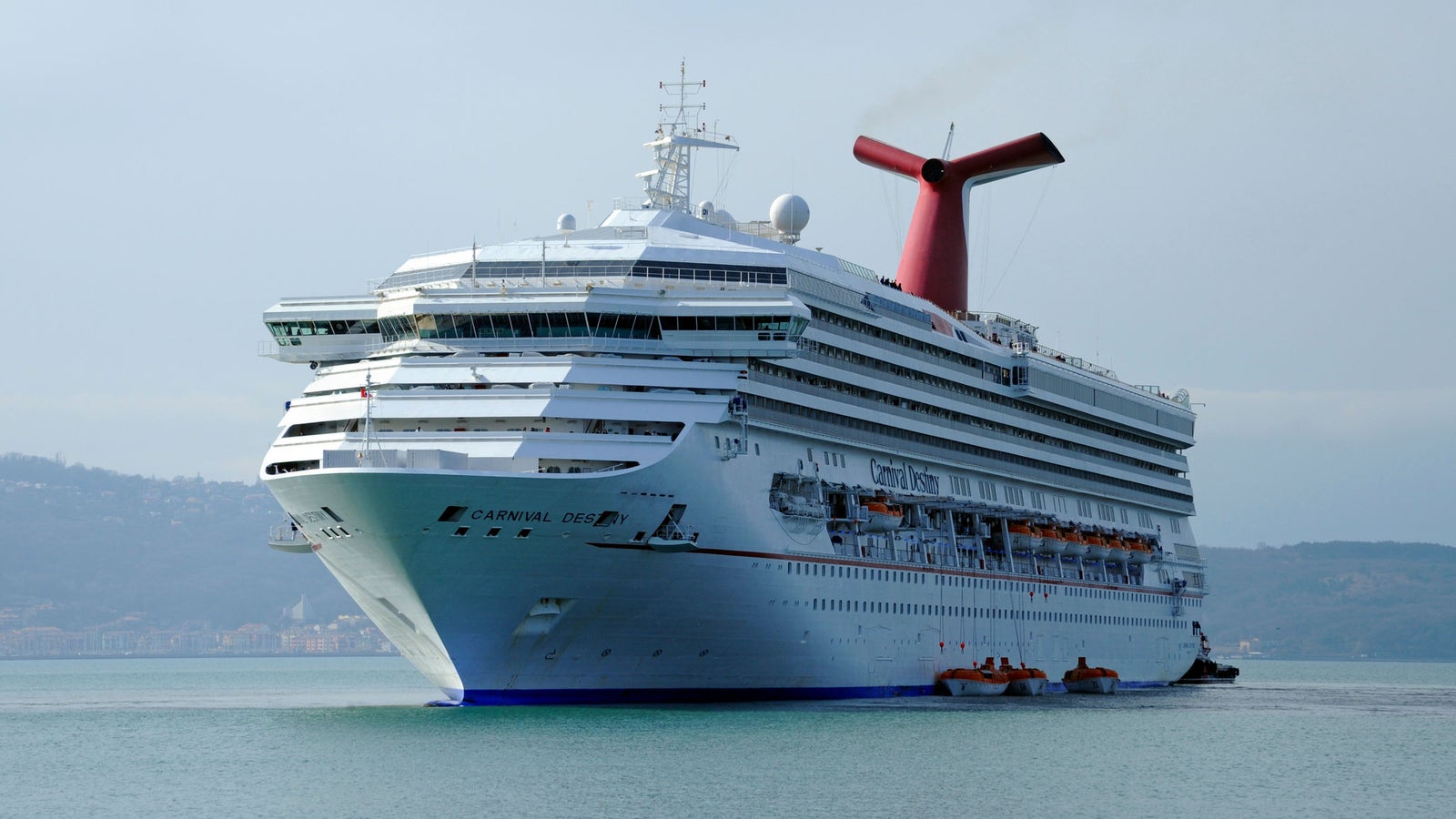 Fincantieri | Group - Business - Products - Cruise Ships - Carnival Destiny: Large white cruise ship identified as 'Carnival Pride' in operation sailing on calm waters, multiple decks, lifeboats, distinctive red funnel.