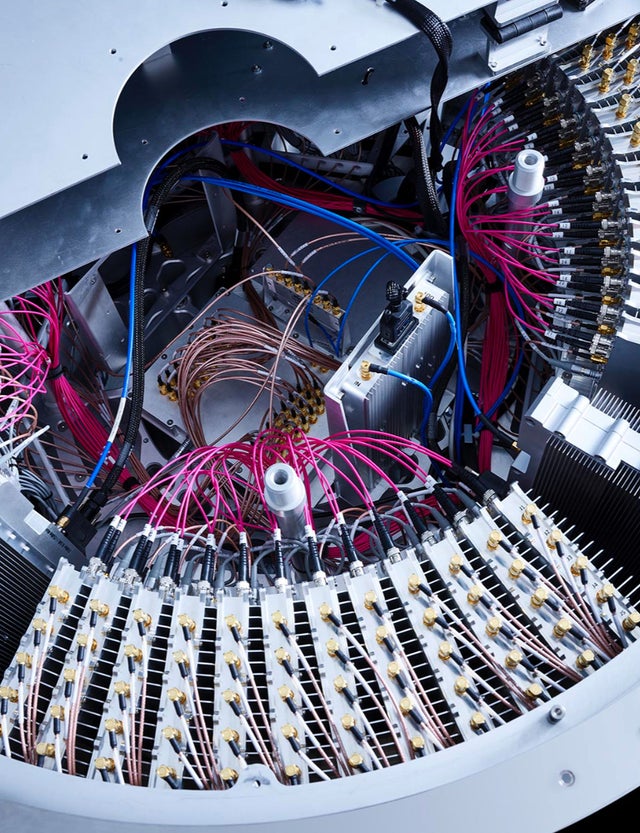 Fincantieri | Group - Sustainability - Responsible Culture - Ethical AI Management: Close-up of a complex optical cable system, numerous pink and blue wires connected to a circular hub, high-tech or industrial environment, intricate wiring and metallic components, highlighting advanced technology and technical precision.