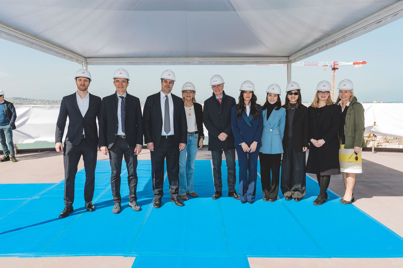 Newsroom - Press releases - 2026 - Fincantieri Group: Fincantieri: “Viking Libra” launched in Ancona, the world’s first hydrogen-powered cruise ship: Group of Fincantieri executives and staff with helmets posing on a blue carpet during the Viking Libra launch ceremony.