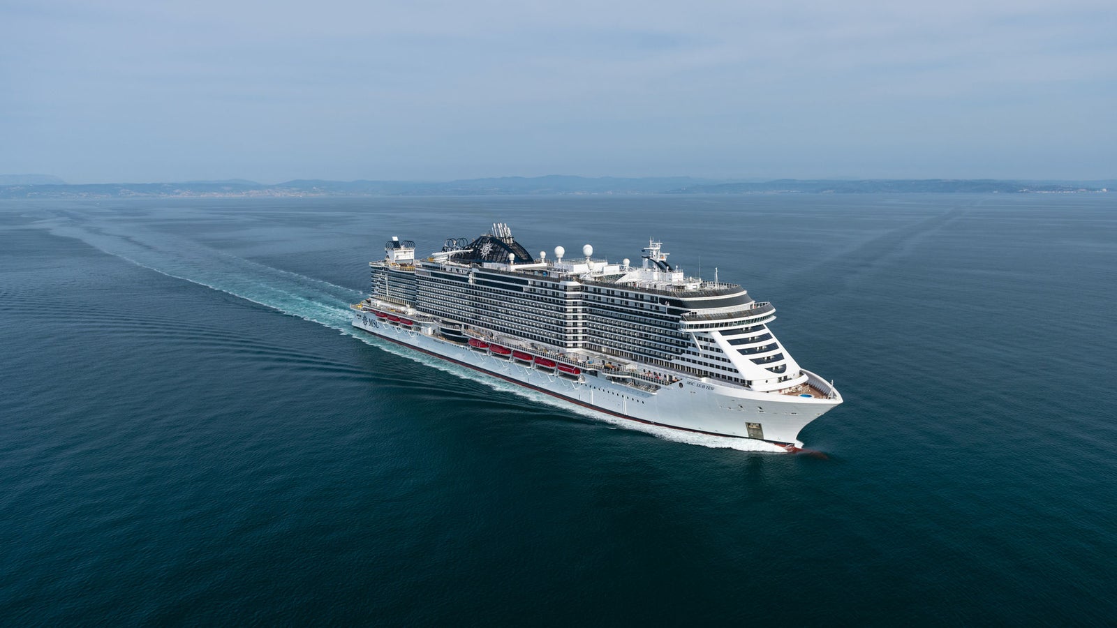 Fincantieri | Gruppo - Business - Prodotti - Navi da Crociera - MSC Seaview: Nave da crociera moderna operativa in navigazione, scafo con design lineare, ponti passeggeri multipli e scialuppe visibili lungo le fiancate.