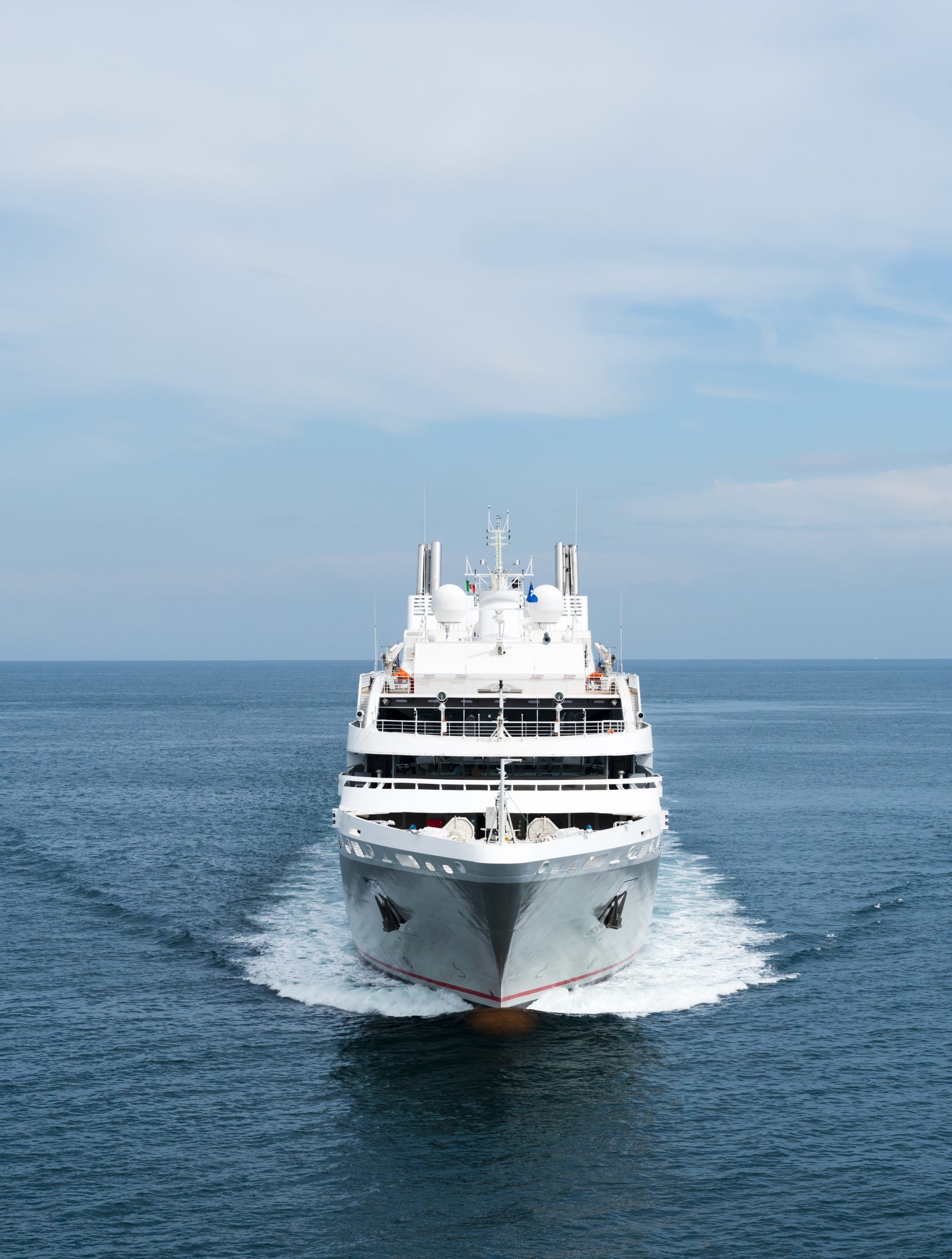 SPGPT (gpt-4.1) Fincantieri | Group - Business - Products - Cruise Ships - Le Soléal: Large white cruise ship in operation sailing forward on calm open waters under partly cloudy sky, multiple decks and sleek design suggest luxurious travel experience, serene ocean setting emphasizes relaxation and adventure