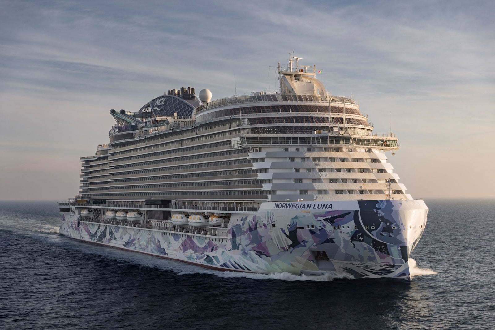 Newsroom - Press releases - 2026 - Fincantieri Group: Fincantieri delivers Norwegian Luna in Marghera: Norwegian Luna cruise ship sailing at sunset, colorful bow livery and lifeboats visible starboard side.