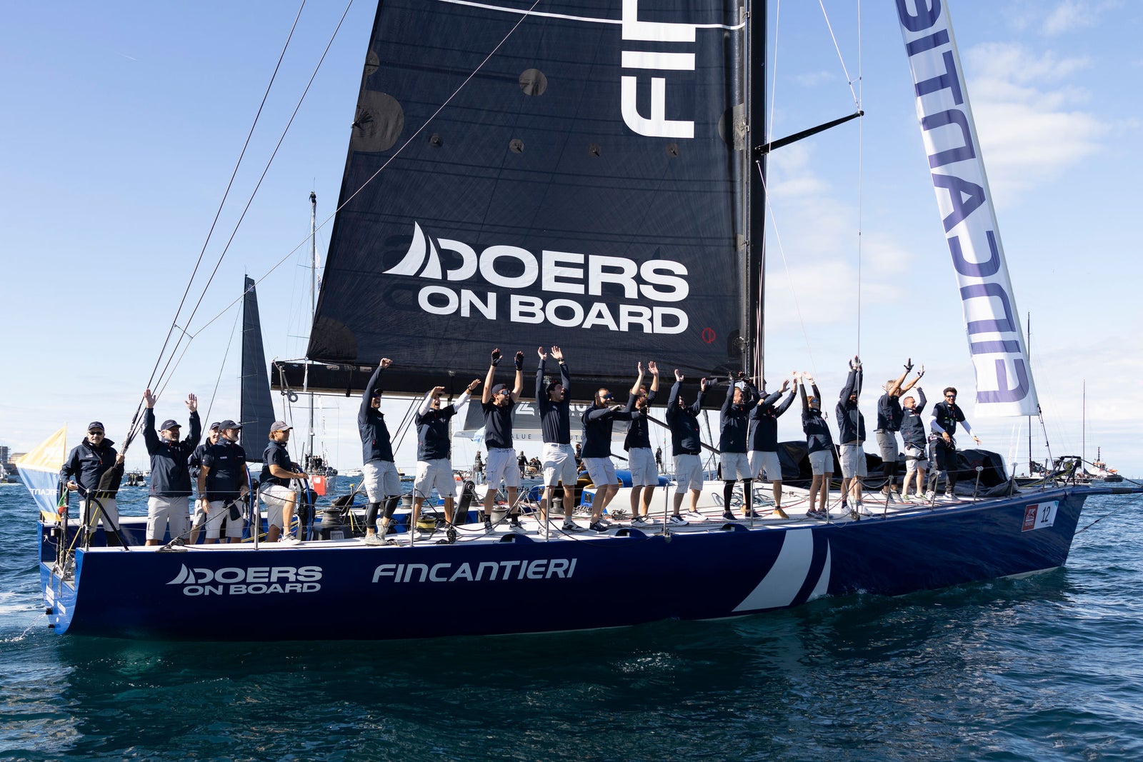 Sailing team celebrating on racing yacht
