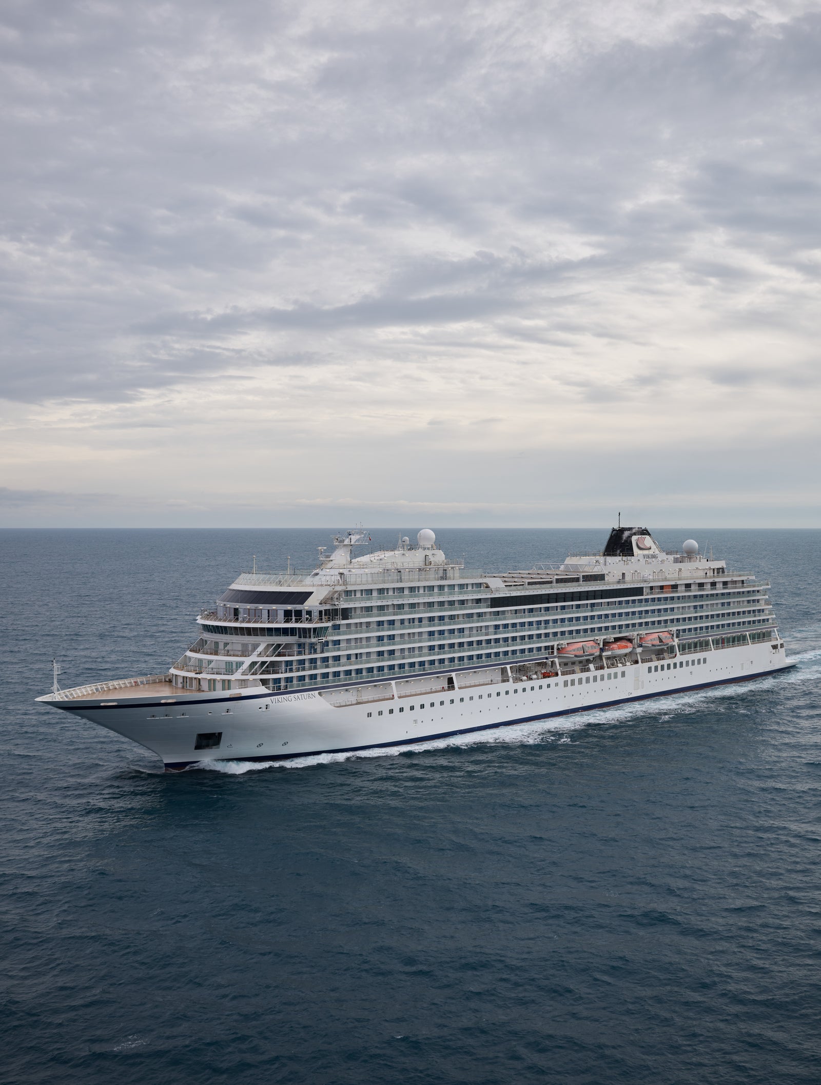 Fincantieri | Gruppo - Business - Prodotti - Navi da Crociera - Viking Orion: Grande nave da crociera moderna operativa in navigazione su acque oceaniche calme sotto cielo nuvoloso, multipli ponti e architettura elegante, scenario che enfatizza tranquillità e vastità del mare, nessuna terra visibile.