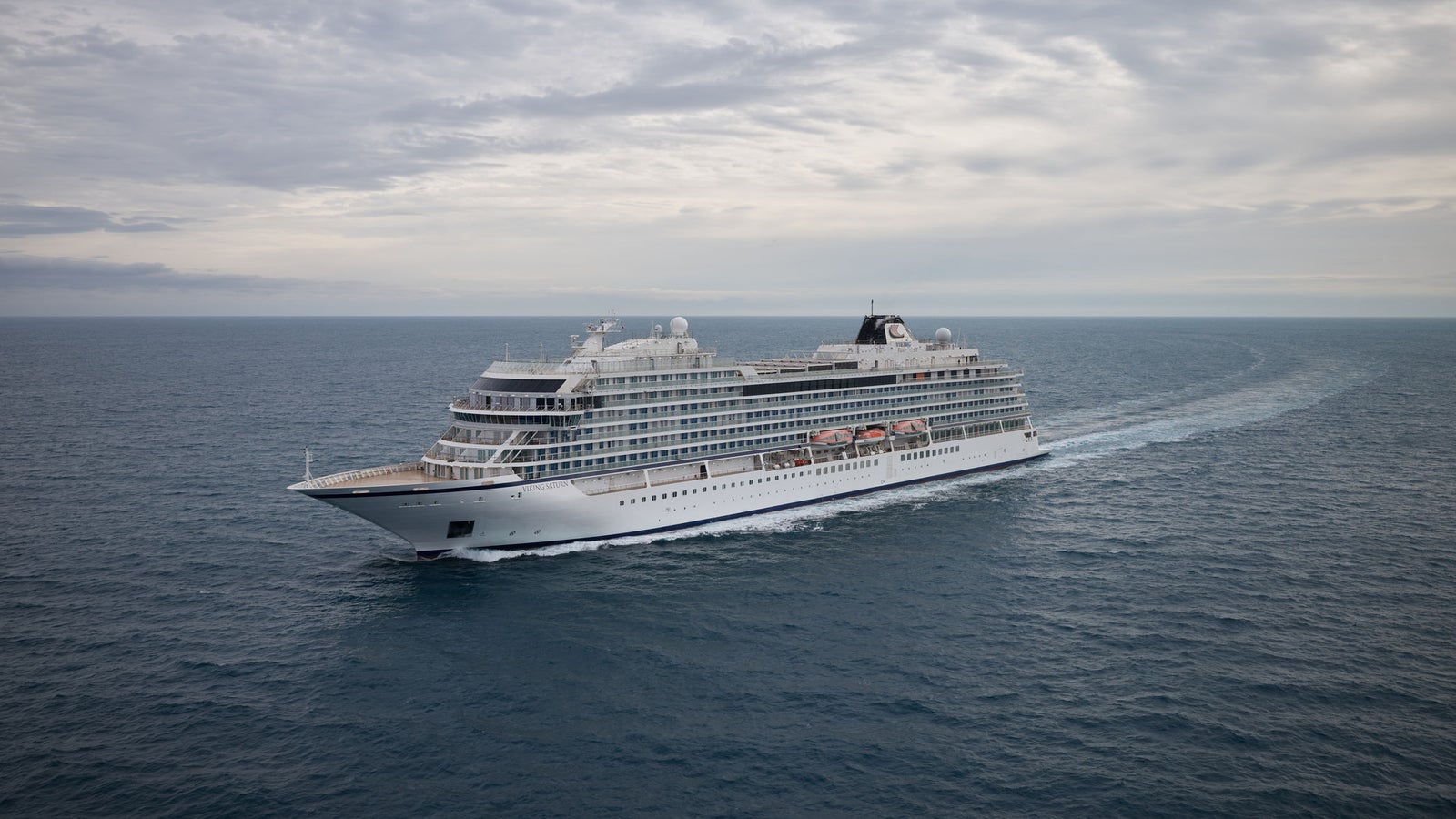 Fincantieri | Gruppo - Business - Prodotti - Navi da Crociera - Viking Orion: Grande nave da crociera moderna operativa in navigazione su acque oceaniche calme sotto cielo nuvoloso, multipli ponti e architettura elegante, scenario che enfatizza tranquillità e vastità del mare, nessuna terra visibile.