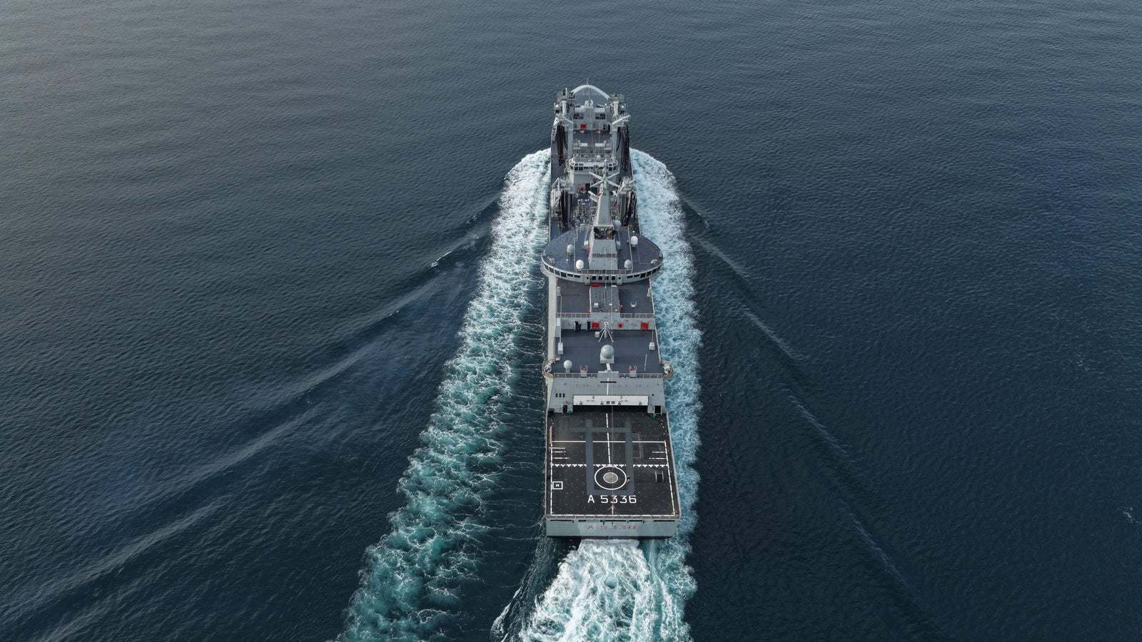 newsroom - press releases - 2025 - fincantieri group: fincantieri delivers "atlante", second lss unit for the italian navy: aerial view of the lss "atlante" naval unit sailing in open sea, visible wake and deck from above.
