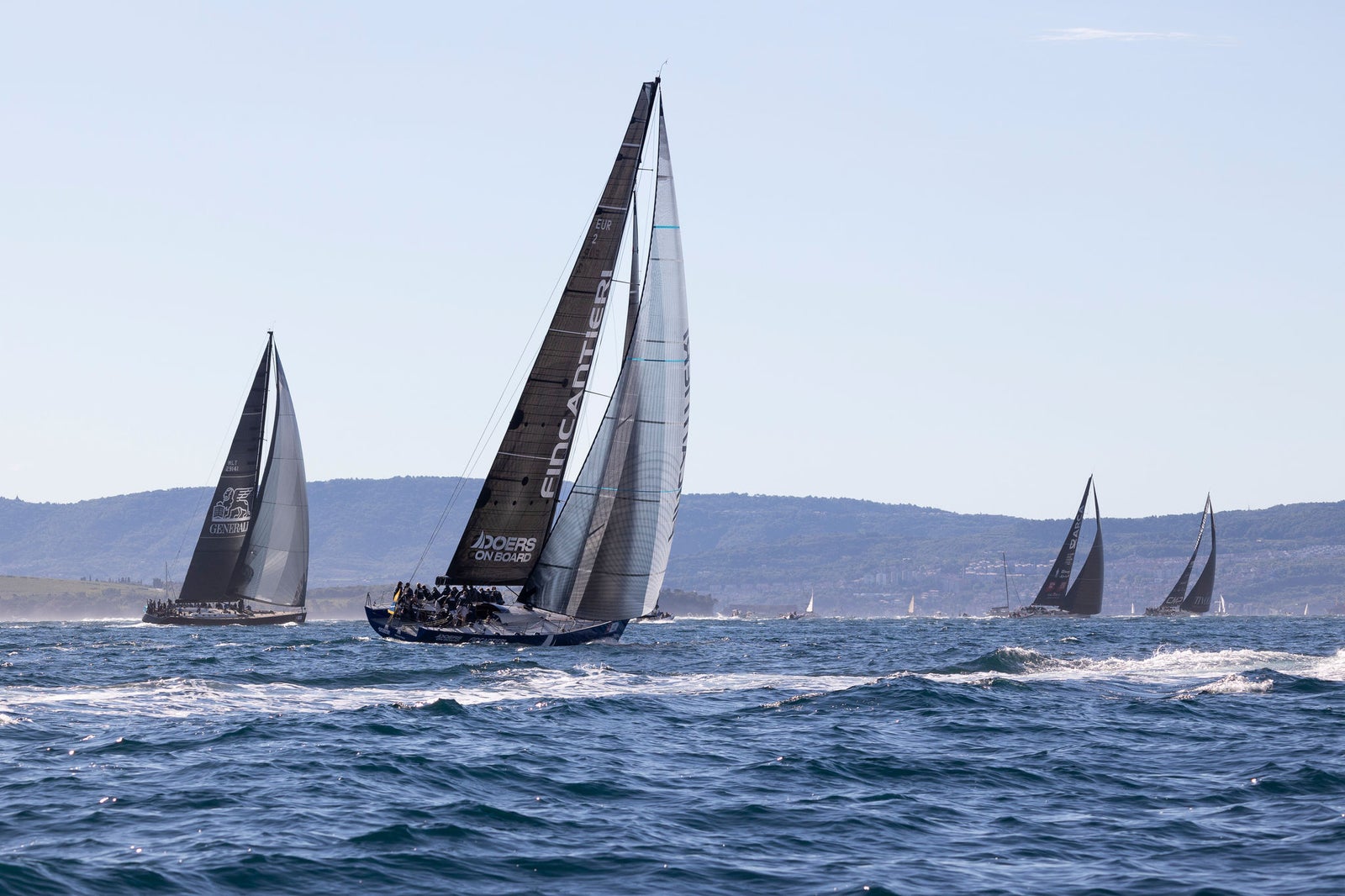 Racing sailboats cutting through open sea