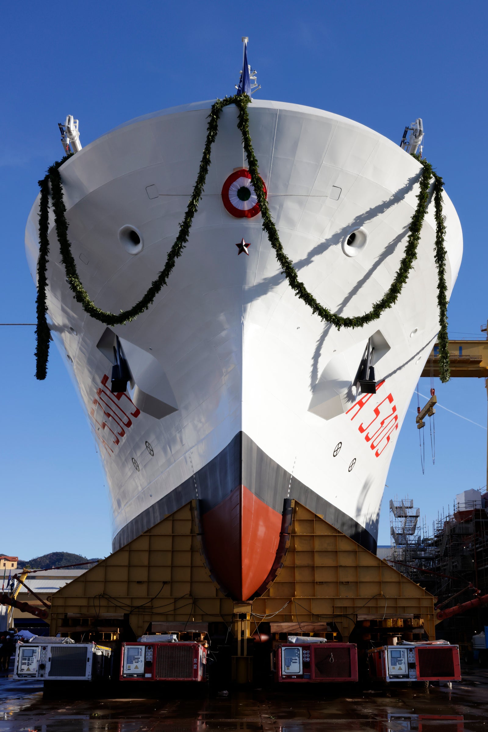 Newsroom - Press releases - 2026 - Fincantieri Group: Launch of the Italian Navy's "Quirinale" major hydro-oceanographic ship: bow of hydro-oceanographic ship "quirinale" a5305 decorated with garlands, red-white rosette, docked at shipyard.