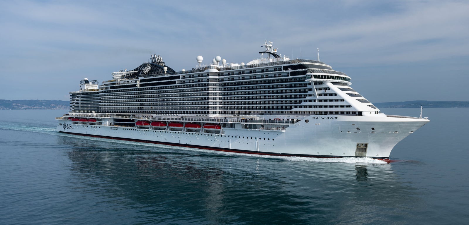  Fincantieri | Gruppo - Business - Prodotti - Navi da Crociera - MSC Seaview: Vista della nave MSC Seaview operativa in navigazione, scafo dal design moderno con ponti passeggeri multilivello e scialuppe visibili sulle fiancate.