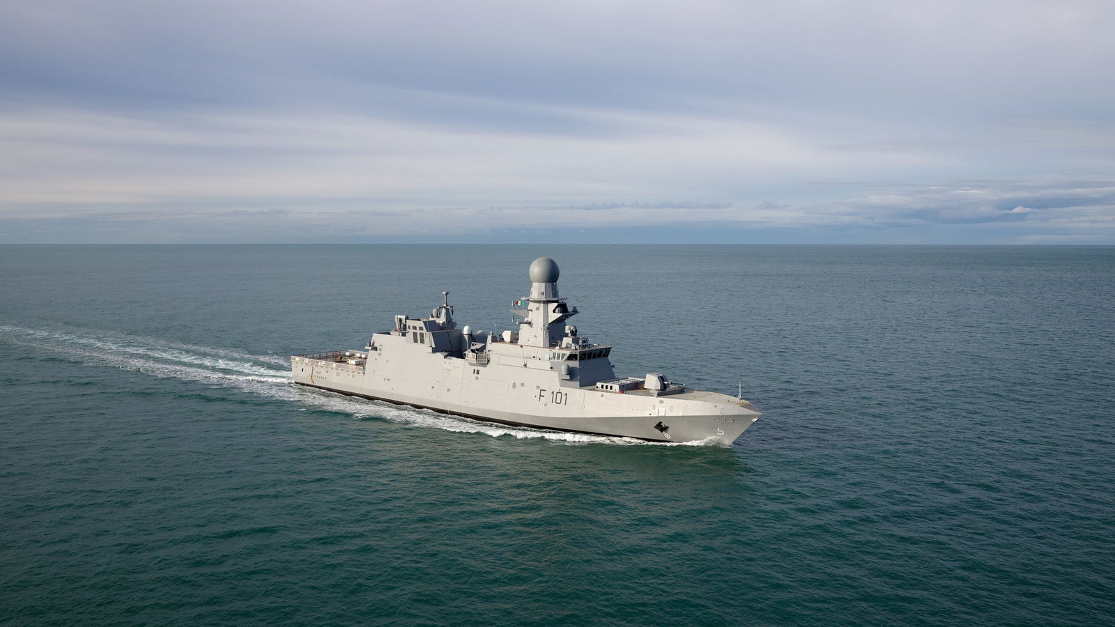 Fincantieri | Group - Business - Products - Defence Vessels - Light Frigates - Al Zubarah class: Side view of operational ship underway, modern design, visible radar and armaments, number F 591 clearly marked on hull.