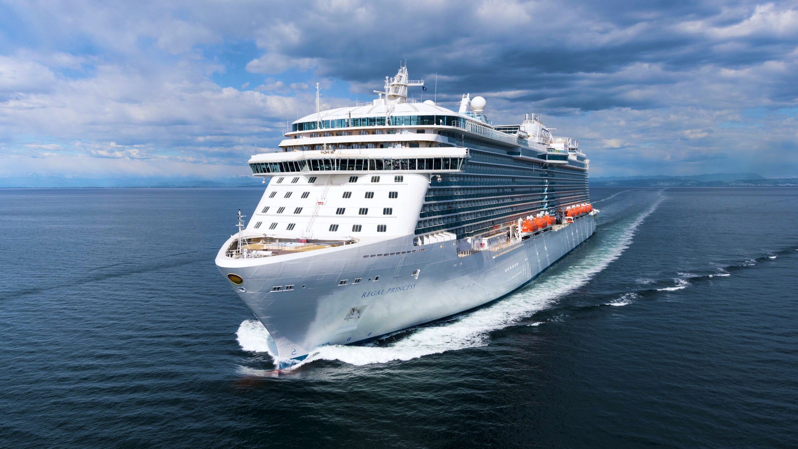 Fincantieri | Group - Business - Products - Cruise Ships - Regal Princess: Large modern operational cruise ship sailing on calm ocean waters under partly cloudy sky, multiple decks and visible lifeboats along sides.