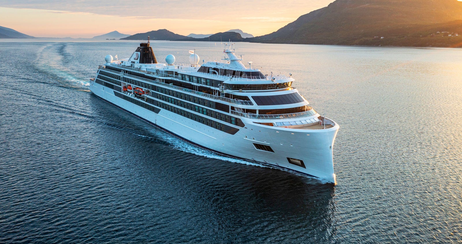  Newsroom - Press releases - 2026 - Fincantieri Group: Fincantieri secures order from Viking for two new expedition vessels: Viking expedition vessel navigates scenic fjord at sunset with visible ship wake, surrounded by mountains.