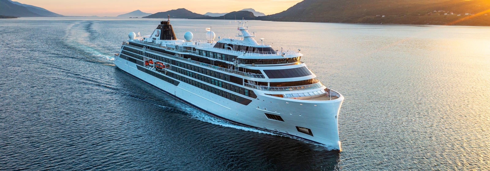  Newsroom - Press releases - 2026 - Fincantieri Group: Fincantieri secures order from Viking for two new expedition vessels: Viking expedition vessel navigates scenic fjord at sunset with visible ship wake, surrounded by mountains.