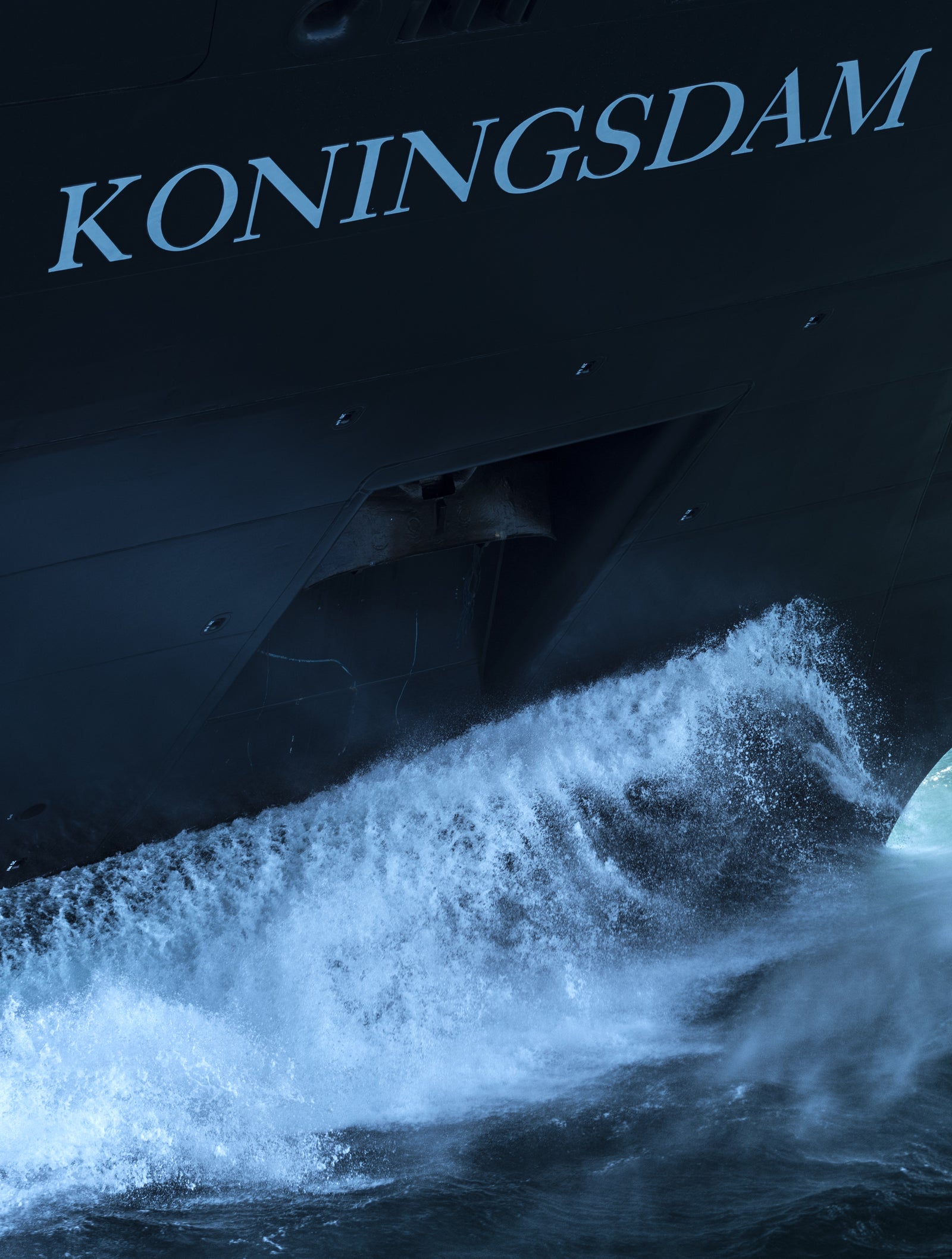 Fincantieri | Gruppo - Business - Prodotti - Navi da Crociera - Koningsdam: Primo piano della prua della nave Koningsdam che taglia le onde, nome visibile sullo scafo, movimento dinamico dell’acqua e design elegante evidenziati.