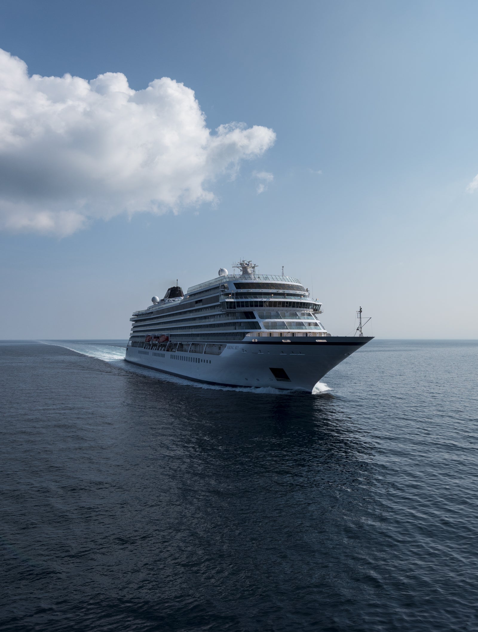 Fincantieri | Group - Business - Products - Cruise Ships - Viking Sky: Side view of Viking Sky cruise ship in operation navigating open sea, white hull, multiple passenger decks, visible balconies along sides.