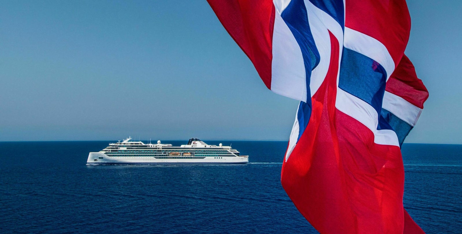 Fincantieri | Group - Business - Products - Cruise Ships - Viking Octantis: Side view of Viking Octantis cruise ship in operation, modern design, Norwegian flag in foreground.
