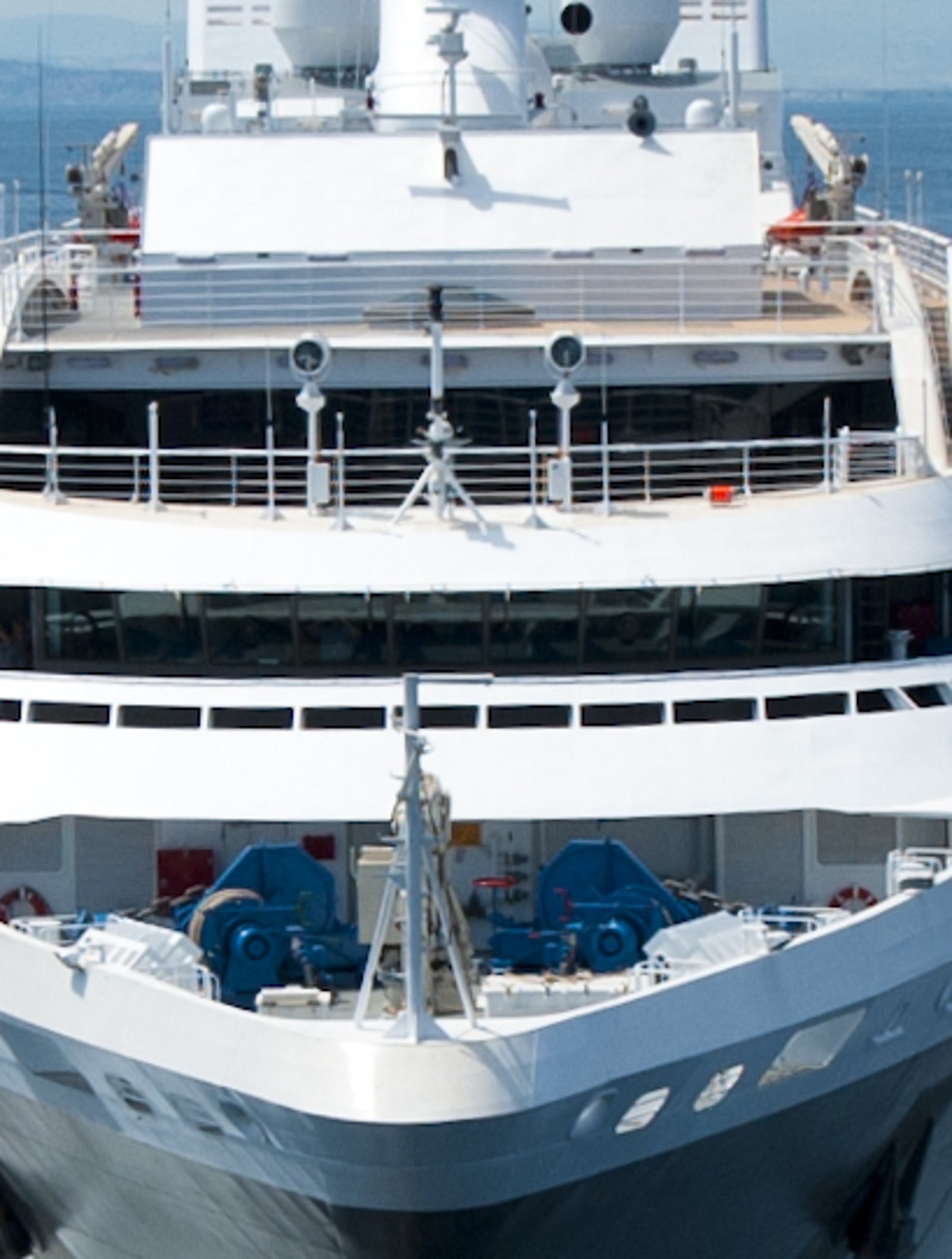  Fincantieri | Group - Business - Products - Cruise Ships - L'Austral: Large modern cruise ship in operation navigating calm open waters under clear blue sky, white with sleek design features, atmosphere of luxury and adventure, ocean stretches endlessly emphasizing tranquility and freedom.