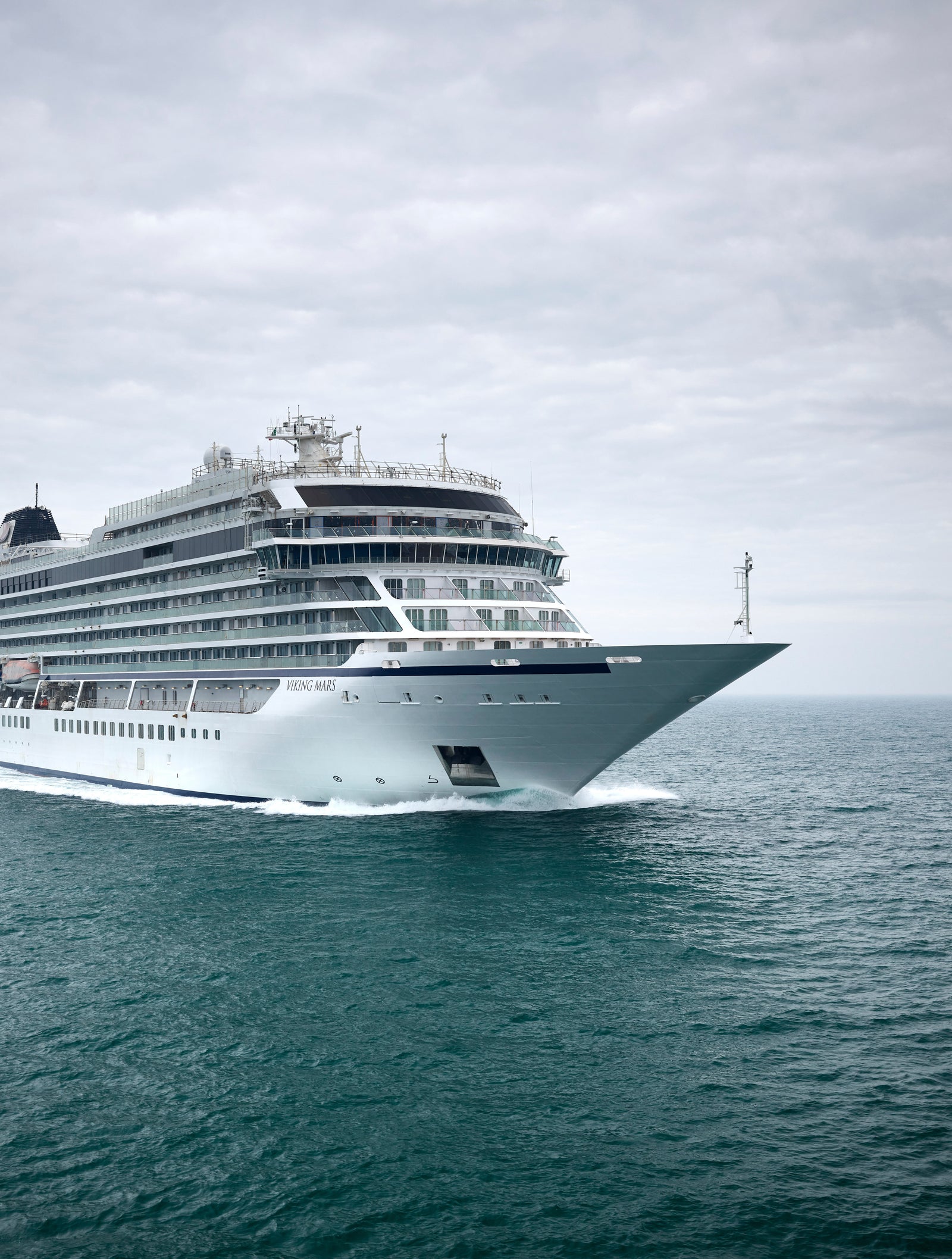  Fincantieri | Group - Business - Products - Cruise Ships - Viking Jupiter: Large modern cruise ship in operation gliding through calm ocean waters under cloudy sky, multiple decks and sleek architecture, setting emphasizes ship’s grandeur and sea vastness.  Fincantieri | Gruppo - Business - Prodotti - Navi da Crociera - Viking Jupiter: Grande nave da crociera moderna operativa che scivola su acque oceaniche calme sotto cielo nuvoloso, multipli ponti e architettura elegante, scenario che enfatizza la maestosità della nave e la vastità del mare.