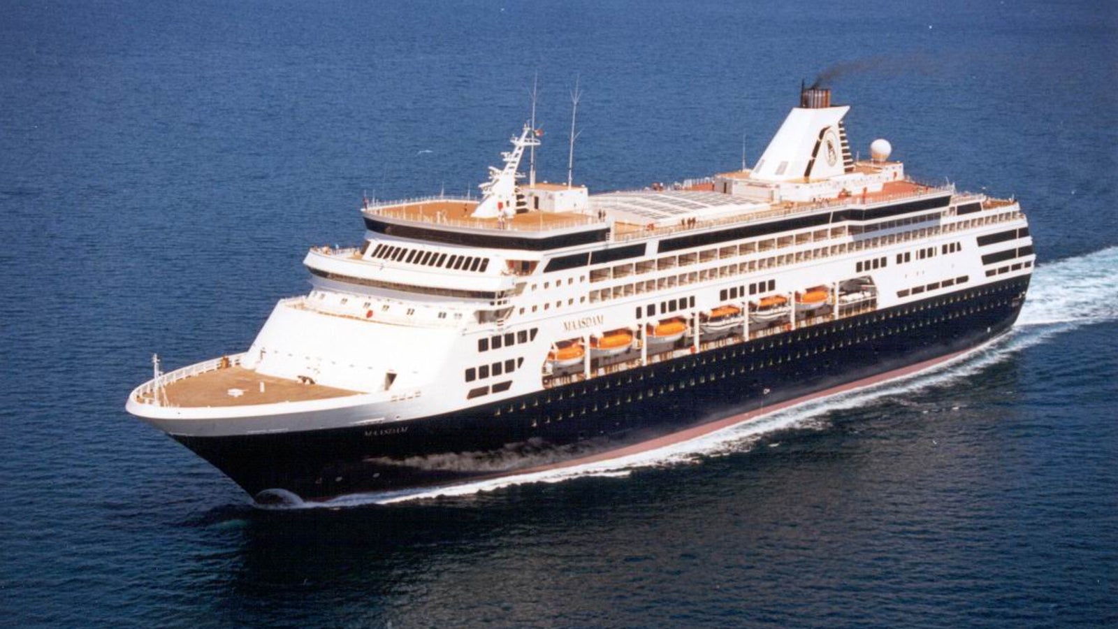Fincantieri | Gruppo - Business - Prodotti - Navi da Crociera - Maasdam: Vista laterale della nave Maasdam operativa in navigazione, multipli ponti, scialuppe visibili, design slanciato, nome Maasdam parzialmente visibile sullo scafo.