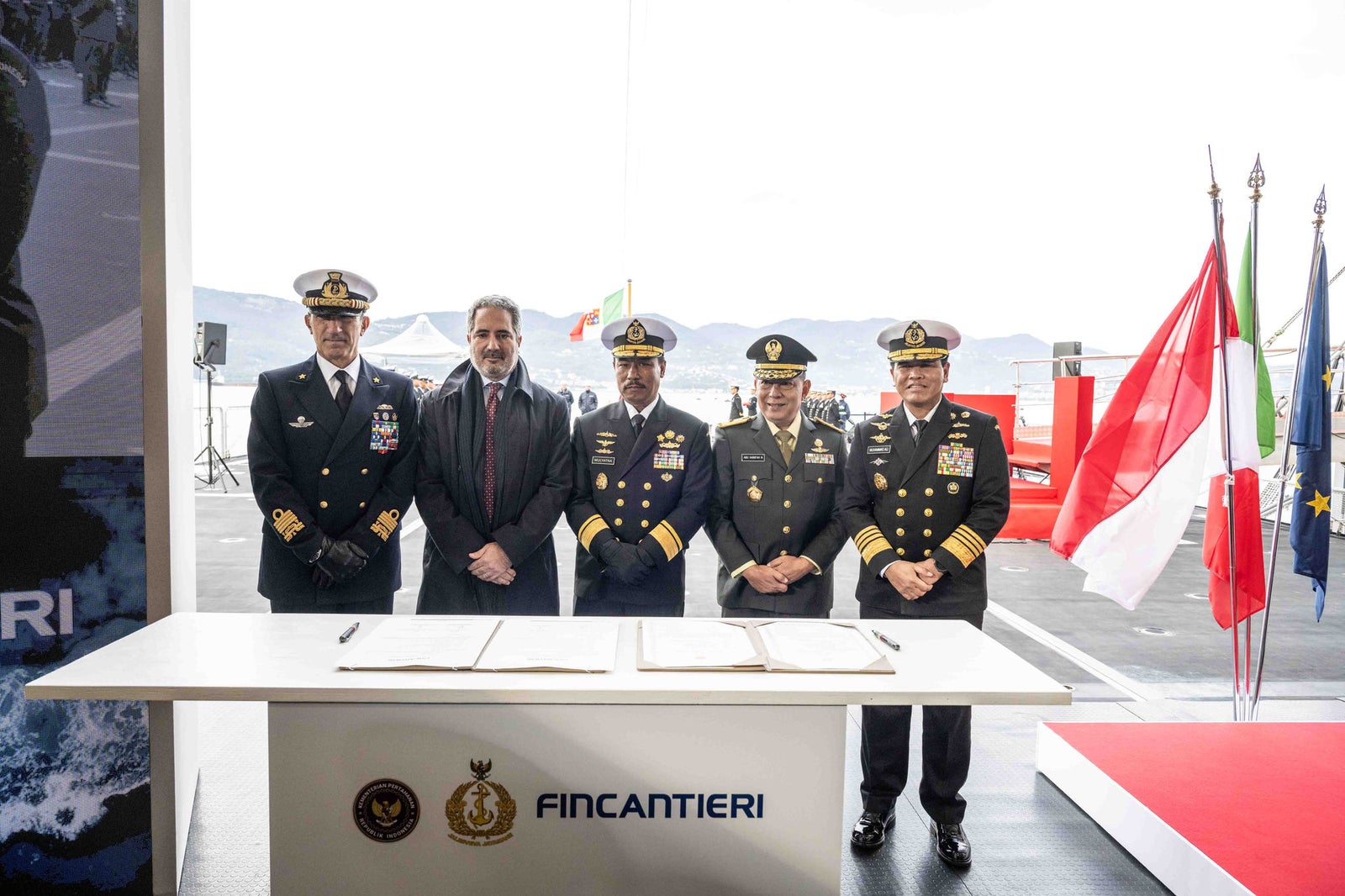 newsroom - press releases - 2025 - fincantieri group: fincantieri delivers the ppa "kri prabu siliwangi-321" to the indonesian navy: official ceremony with uniformed officers and representatives in front of the fincantieri desk, italian, indonesian and european flags in the background.