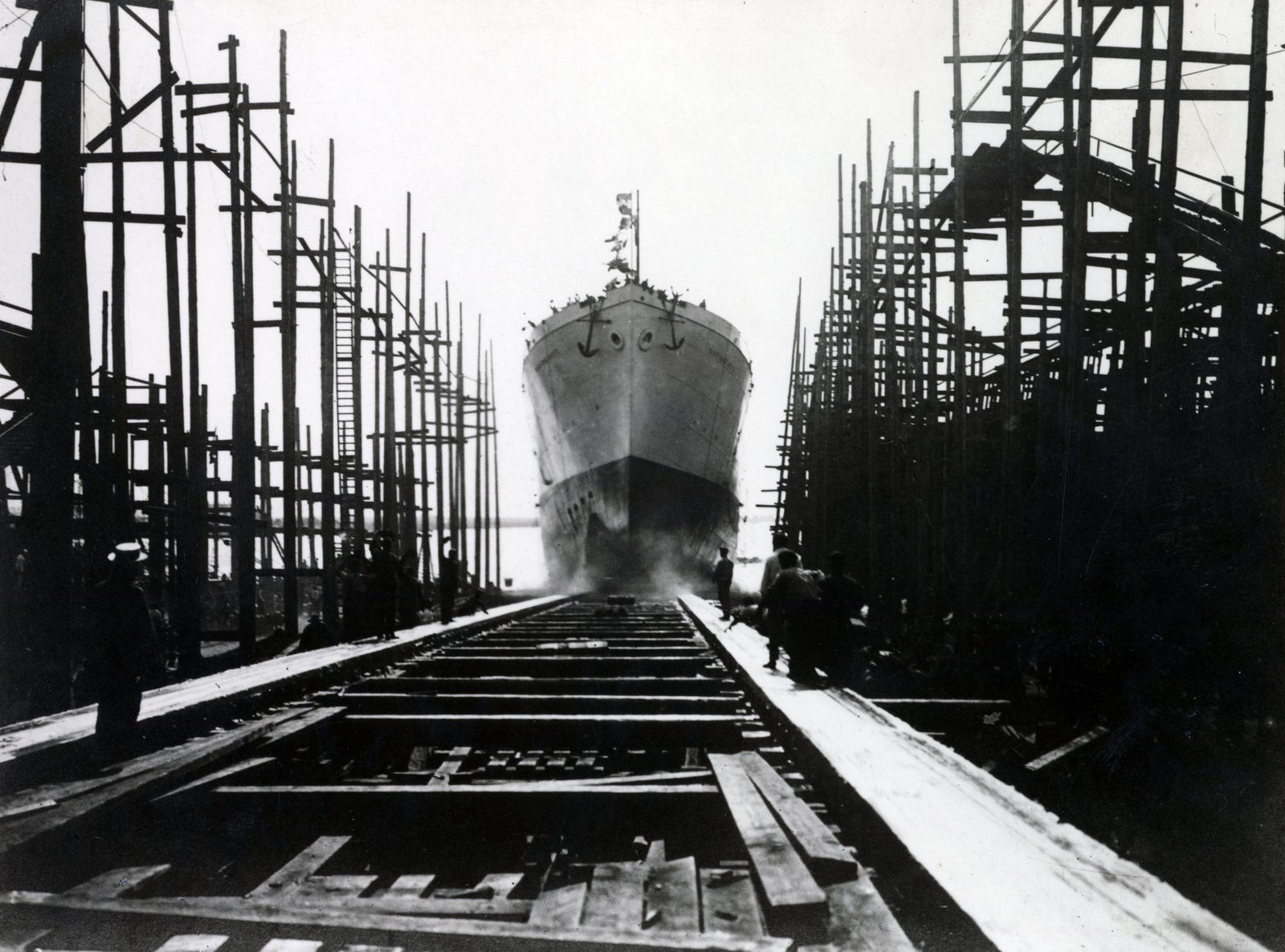 newsroom - press releases - 2026 - fincantieri group - fincantieri foundation: the first volume of the series on the history of italian shipbuilding now available in bookstores: fotografia storica in bianco e nero di nave in scivolamento durante il varo tra impalcature in cantiere navale.