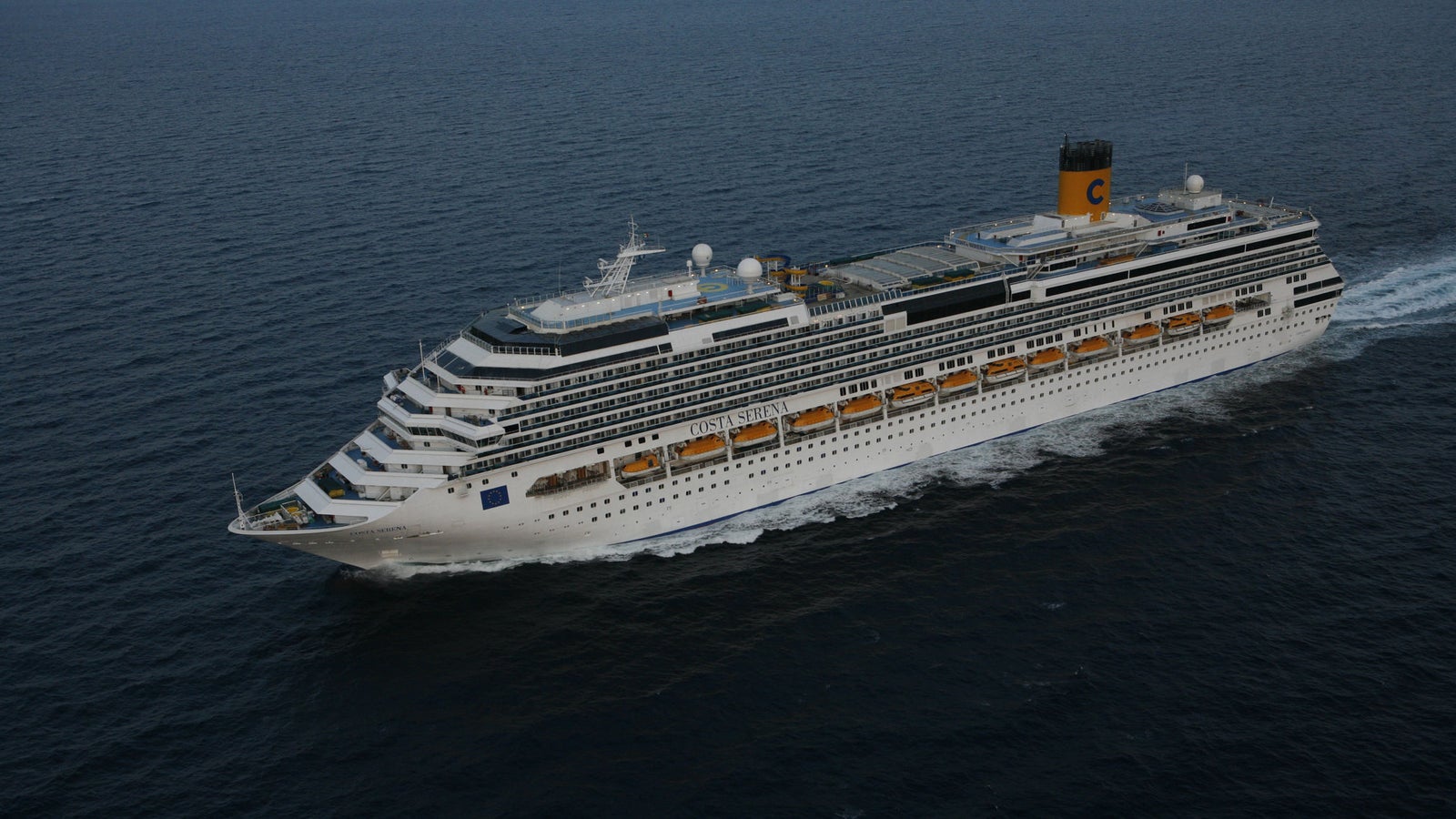 incantieri | Gruppo - Business - Prodotti - Navi da Crociera - Costa Pacifica: Nave da crociera bianca imponente operativa che naviga su acque calme e aperte, più ponti, camino giallo distintivo con logo 'C' visibile, scenario sereno senza altre navi o terra, evidenzia la vastità dell’oceano.