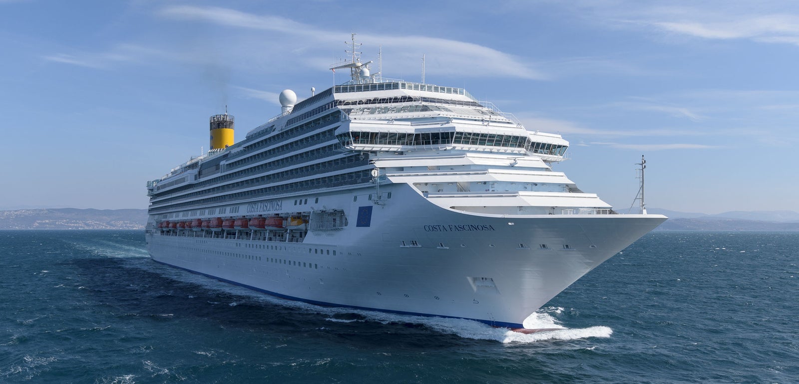  Fincantieri | Group - Business - Products - Cruise Ships - Costa Diadema: Massive white cruise ship in operation sailing through calm open waters under clear blue sky, multiple decks and visible lifeboats along sides, 'Costa Diadema' name clearly displayed on hull.