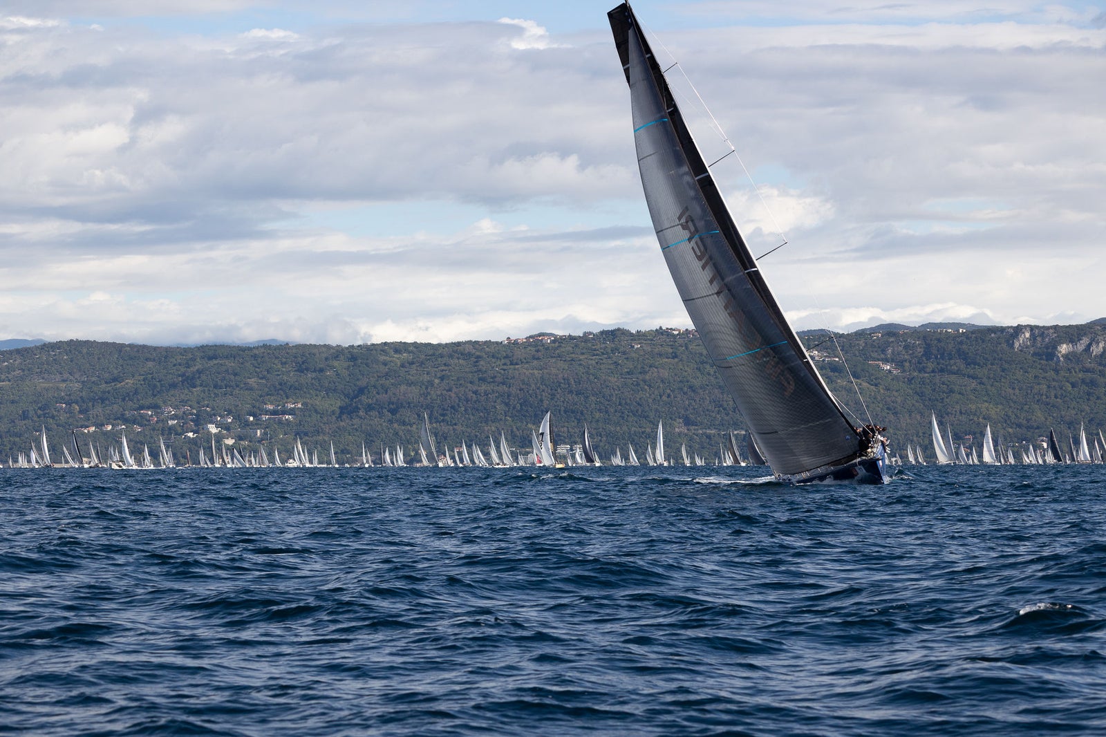 Racing sailboat on choppy coastal waters