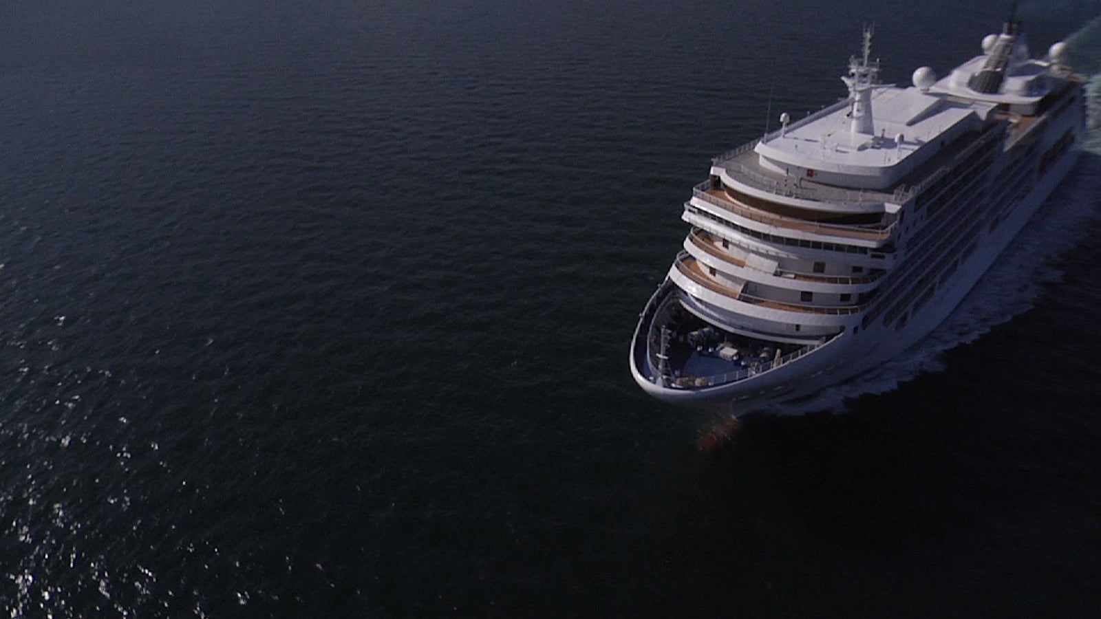 Fincantieri | Group - Business - Products - Cruise Ships - Silver Spirit: Large modern operational cruise ship with multiple decks and visible balconies, sailing on calm waters under clear sky, elegant exterior and visible lifeboats, atmosphere of relaxation and luxury ideal for exclusive travel experiences.
