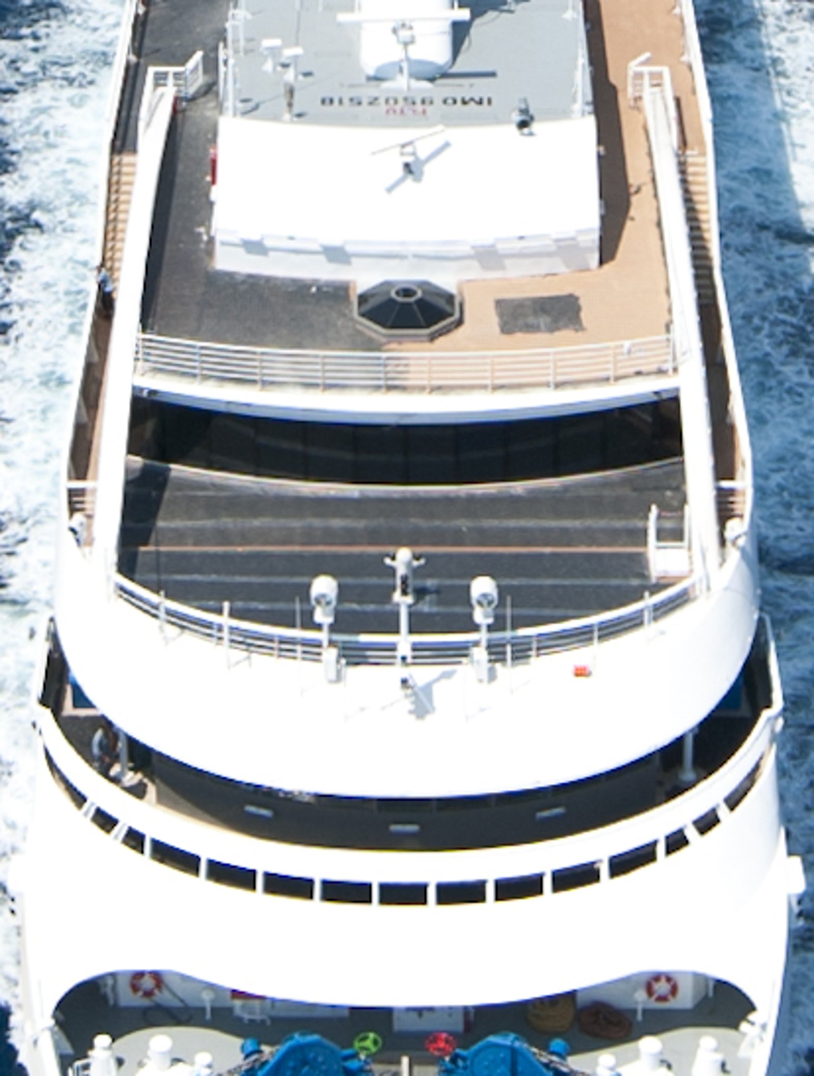 Fincantieri | Group - Business - Products - Cruise Ships - L'Austral: Sleek luxury yacht in operation navigating calm deep blue open ocean under bright sky, modern design with spacious decks and visible amenities, serene setting highlights sea tranquility and exclusivity of experience.