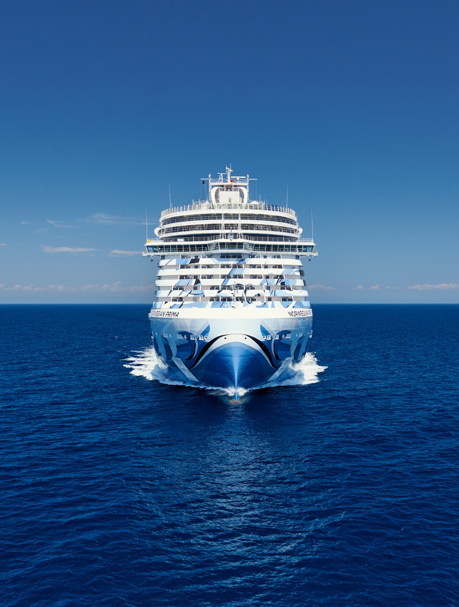 Fincantieri | Group - Business - Products - Cruise Ships - Norwegian Prima: Bow view of Norwegian Prima cruise ship in operation, distinctive painted design on bow, large luxurious structure.